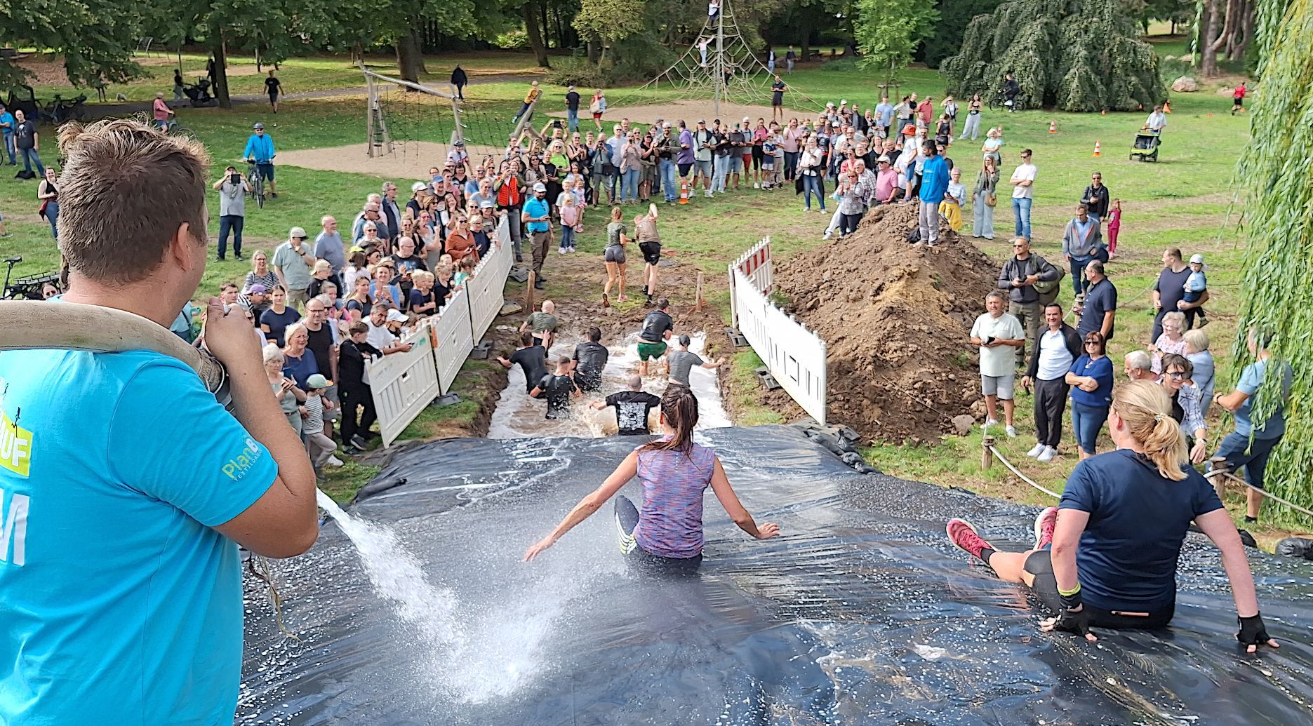 Die Rutsche ist von zahlreichen Zuschauerinnen und Zuschauern gesäumt.