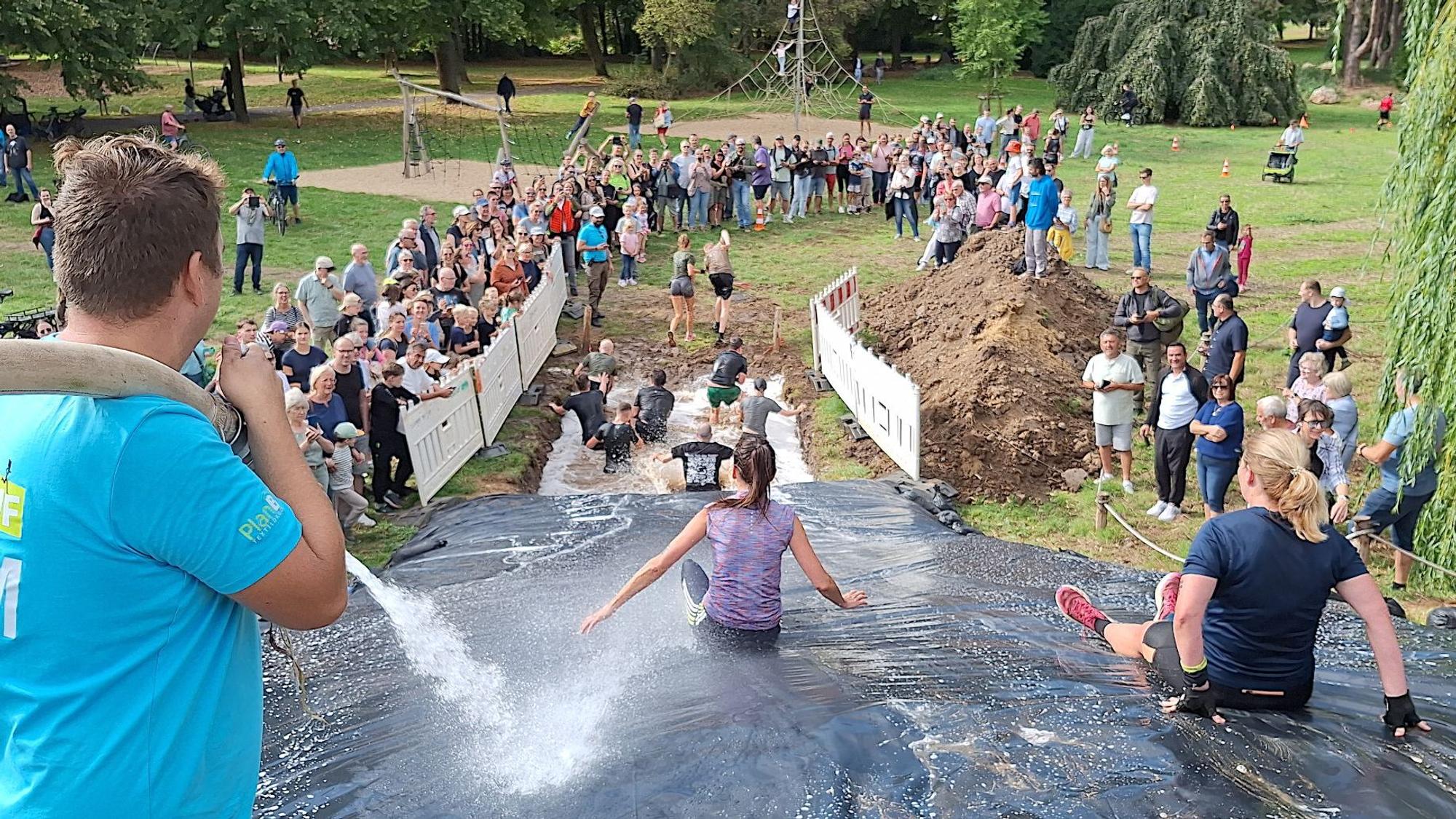 Die Rutsche ist von zahlreichen Zuschauerinnen und Zuschauern gesäumt.