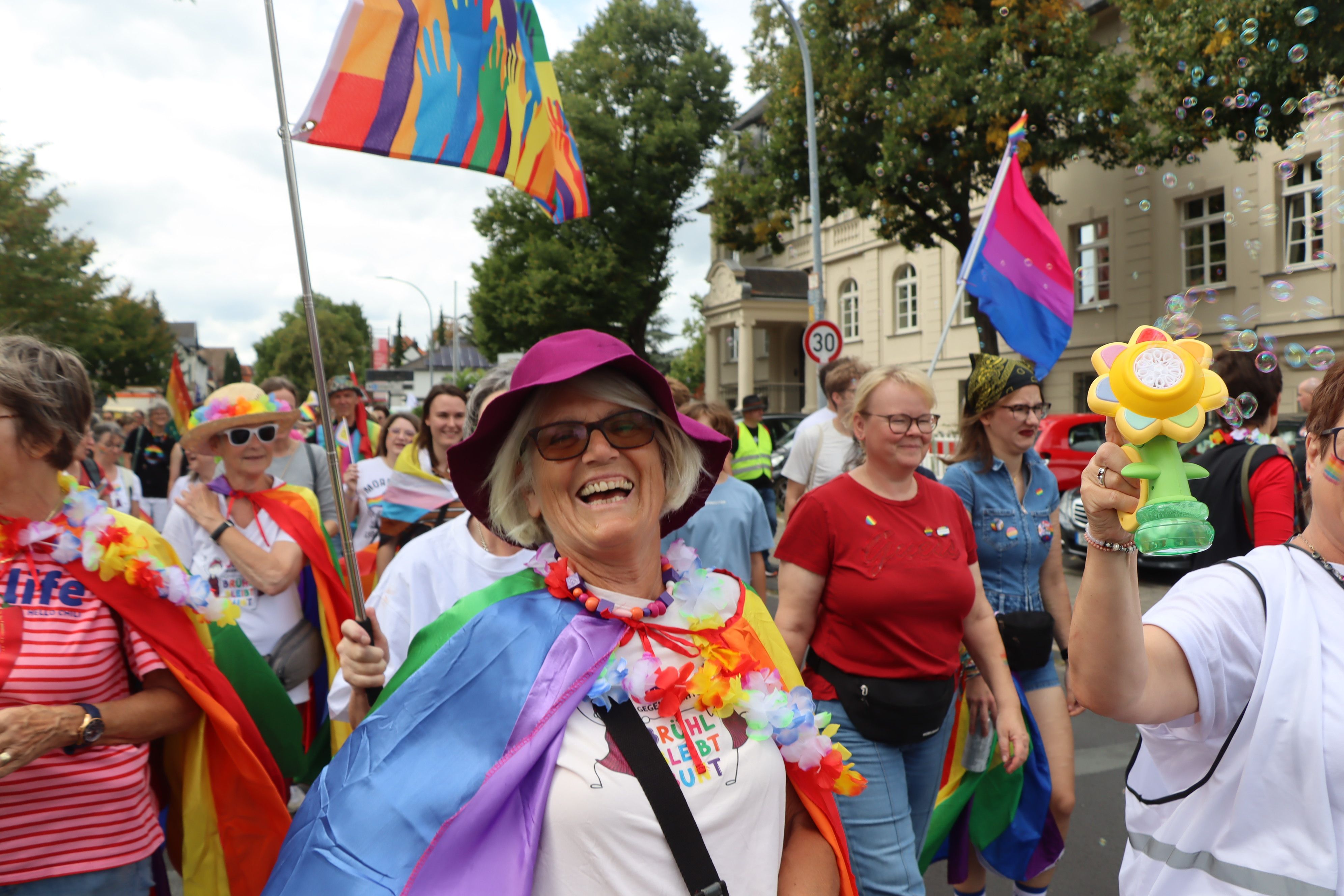 Zu sehen sind bunt gekleidete Menschen in der Brühler Innenstadt.