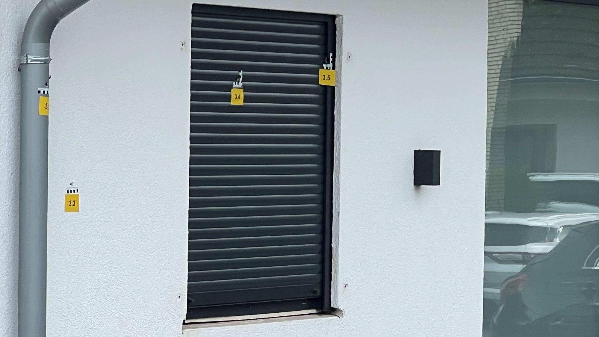 Die Polizei markierte mehrere Einschusslöcher an der Hausfassade.