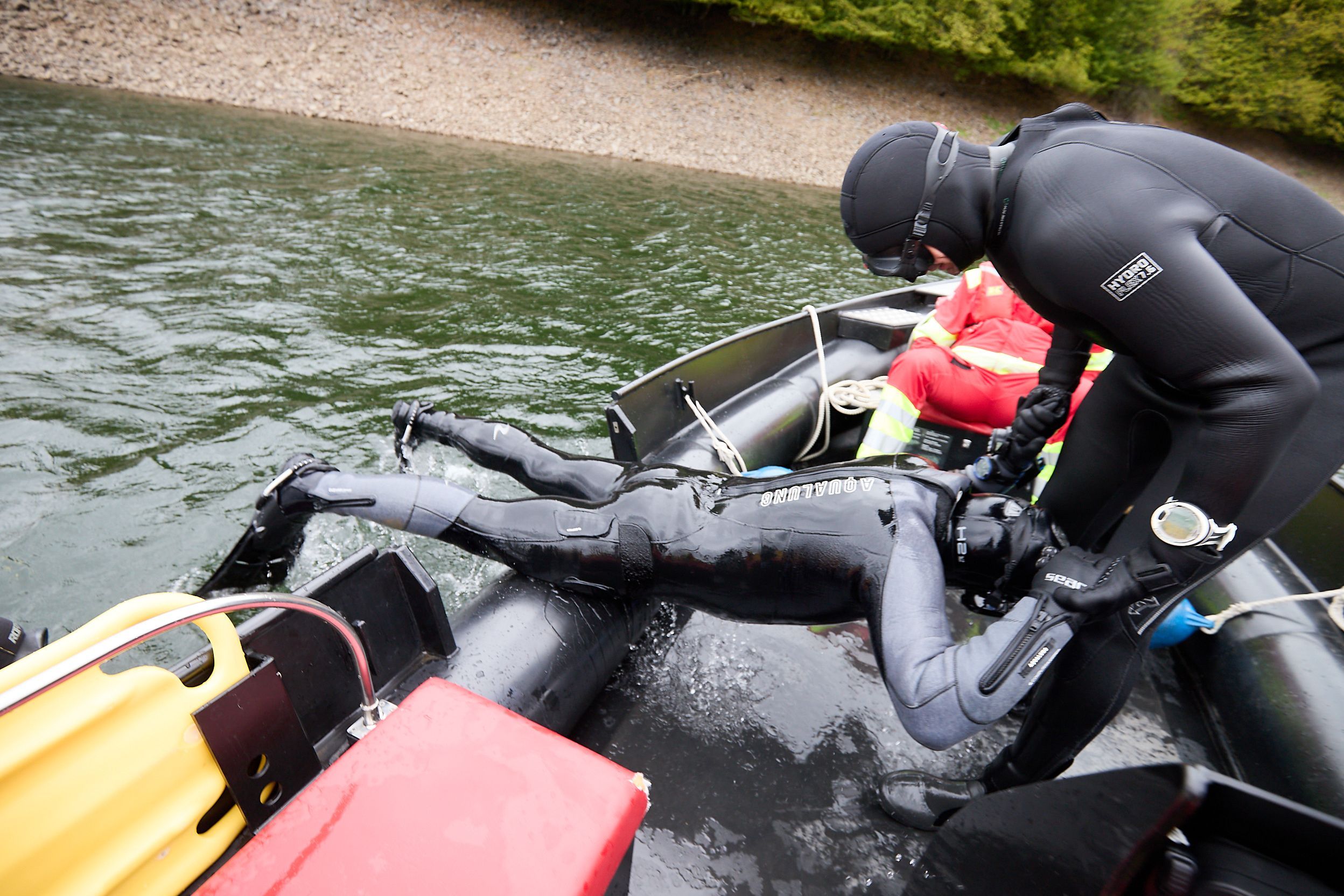Der Taucher wird von einem Kollegen aus dem Wasser geholt.