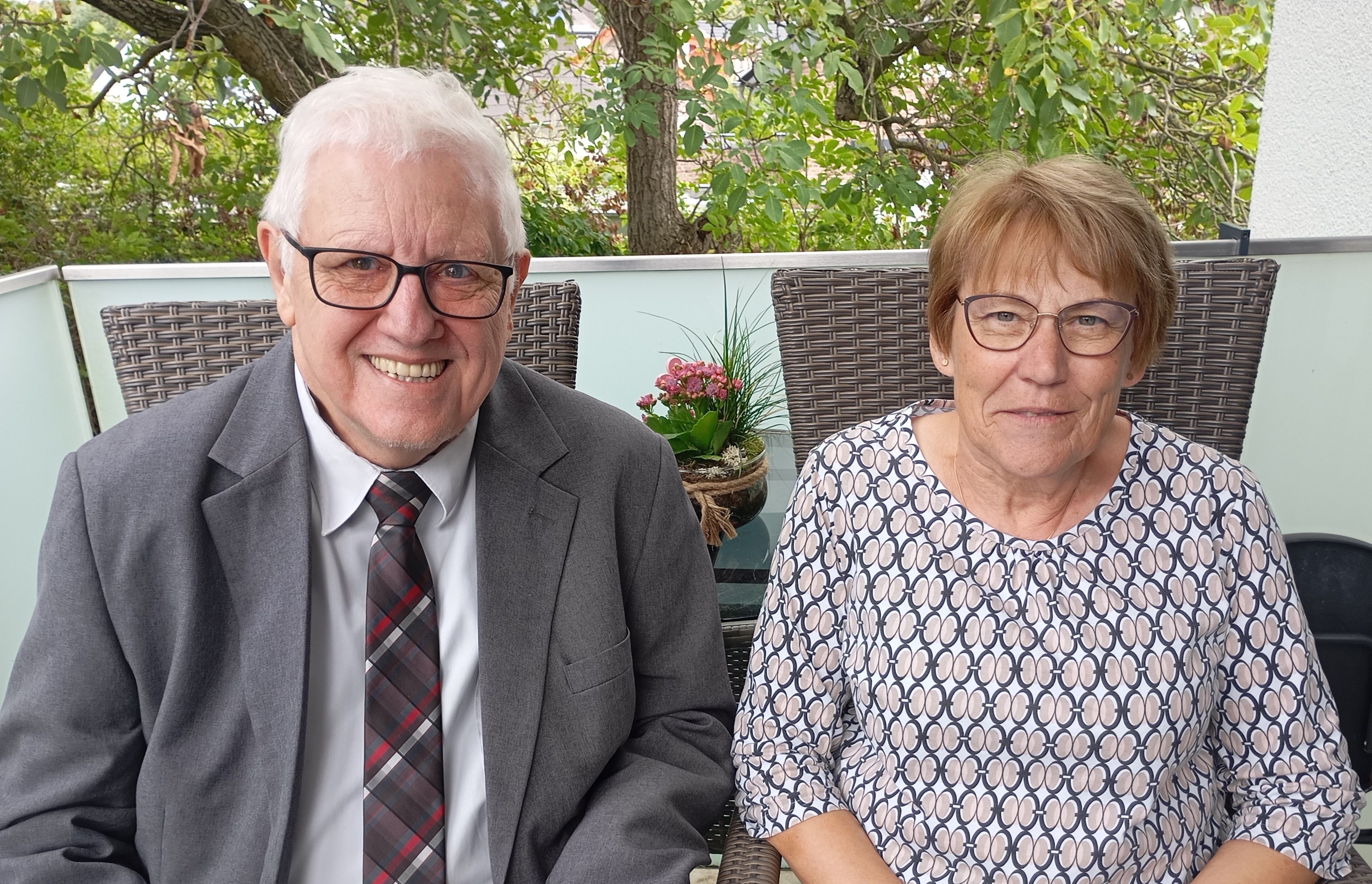 Ein Ehepaar sitzt auf einer Terrasse.