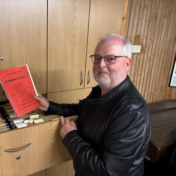 Auf dem Bild ist ein Mann an einem Aktenschrank zu sehen.