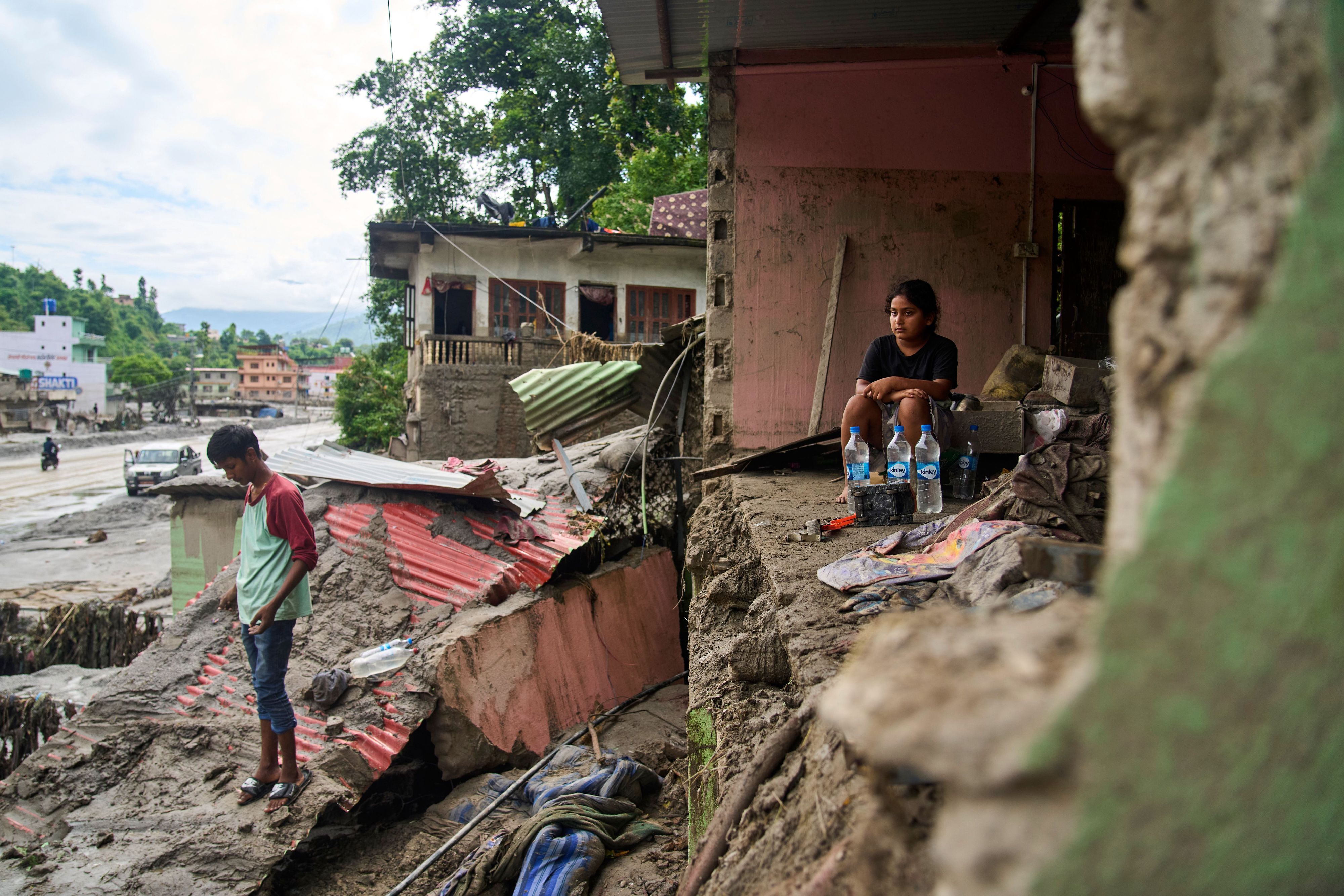 Das Foto wurde aufgenommen im nepalesischen Dhading: Ein Mädchen sitzt in einem Gebäude, das durch die Sturzfluten beschädigt wurde.