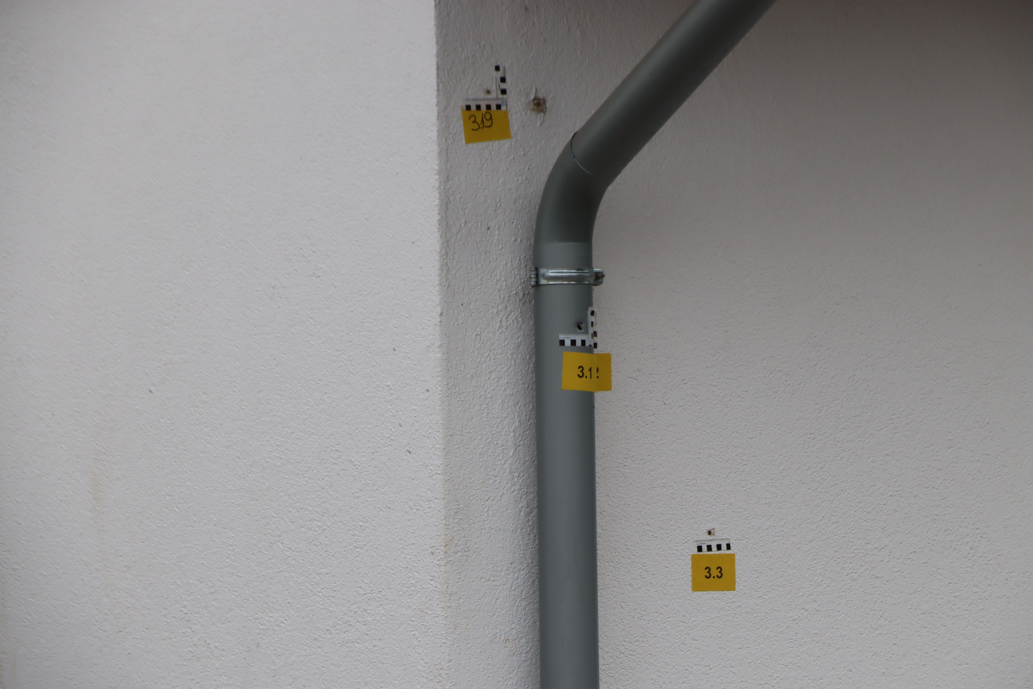 Deutlich sind die Einschusslöcher in der Hauswand und im Abflussrohr zu sehen.