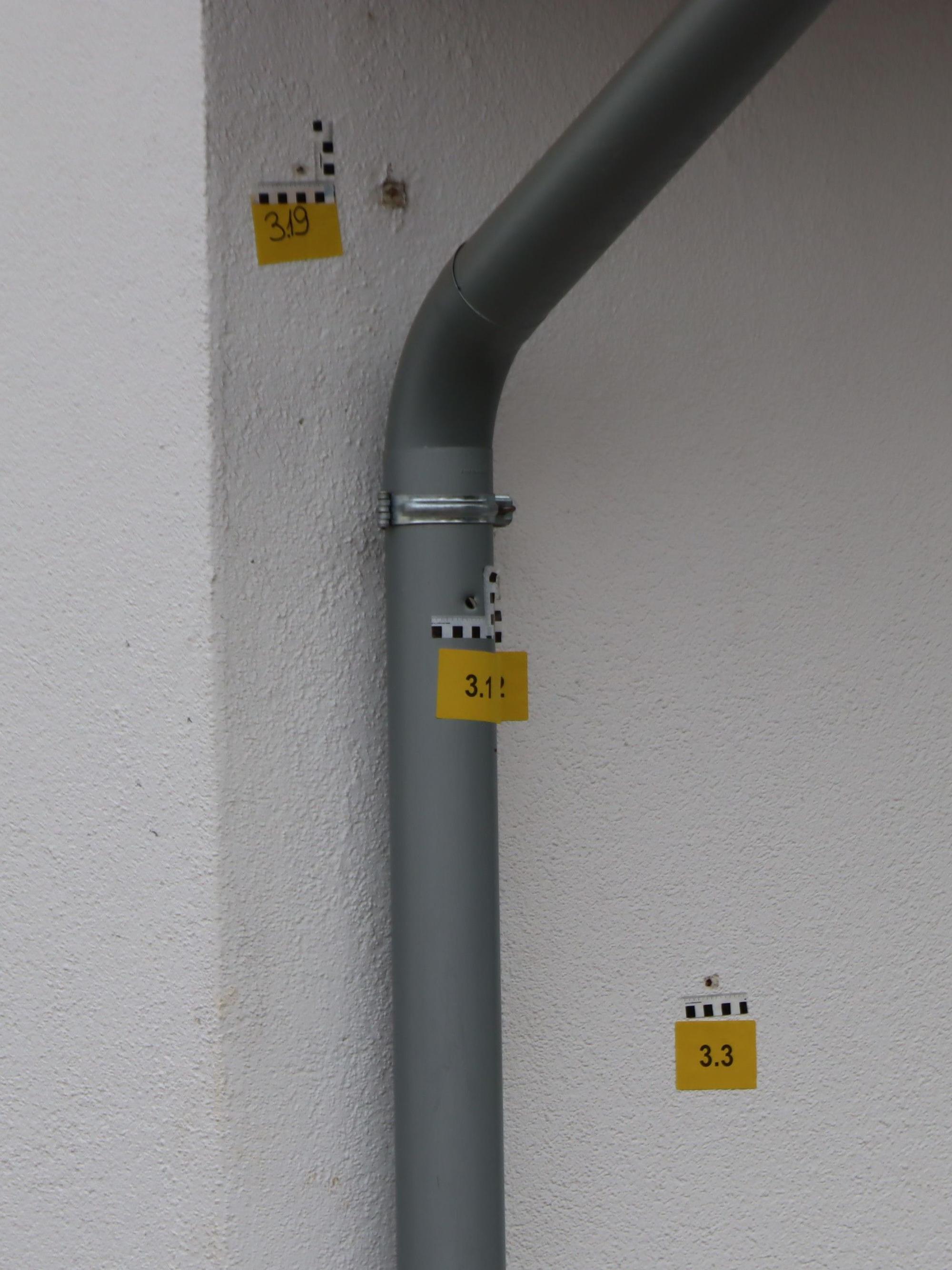 Deutlich sind die Einschusslöcher in der Hauswand und im Abflussrohr zu sehen.