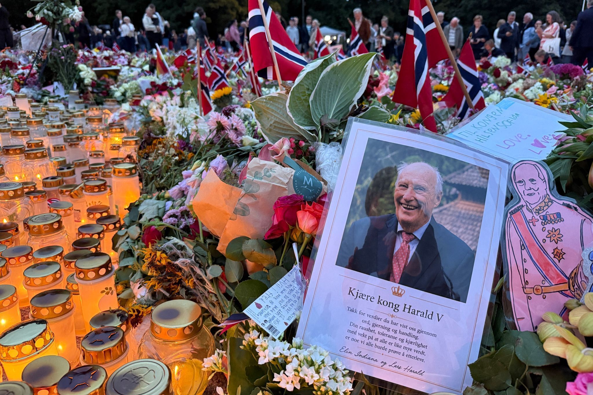 Nach dem Tod von König Harald stehen Kerzen, Blumen und Flaggen vor dem Schloss.
