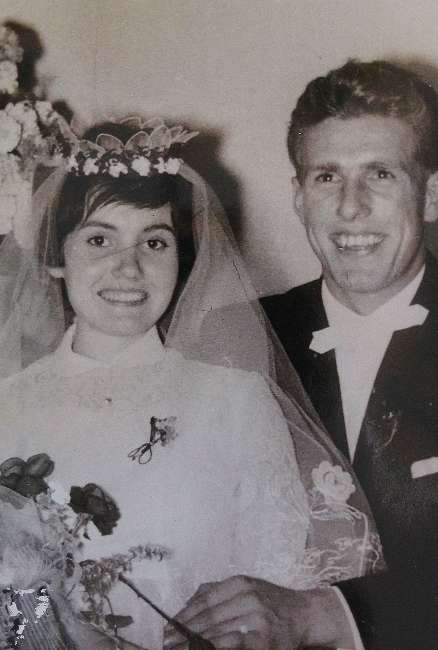 Eine Frau und ein Mann, sie trägt ein weißes Hochzeitskleid mit Schleier.
