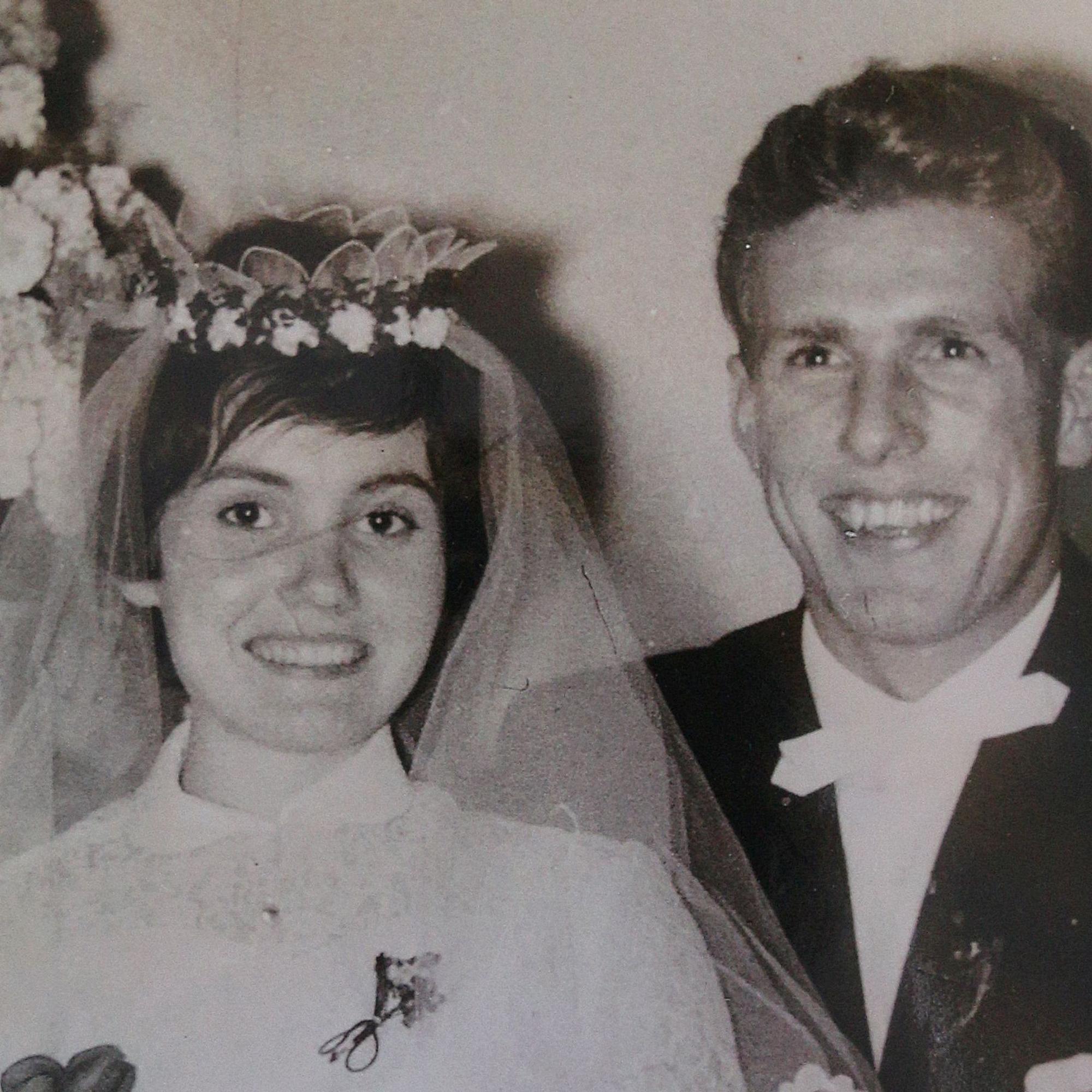 Eine Frau und ein Mann, sie trägt ein weißes Hochzeitskleid mit Schleier.
