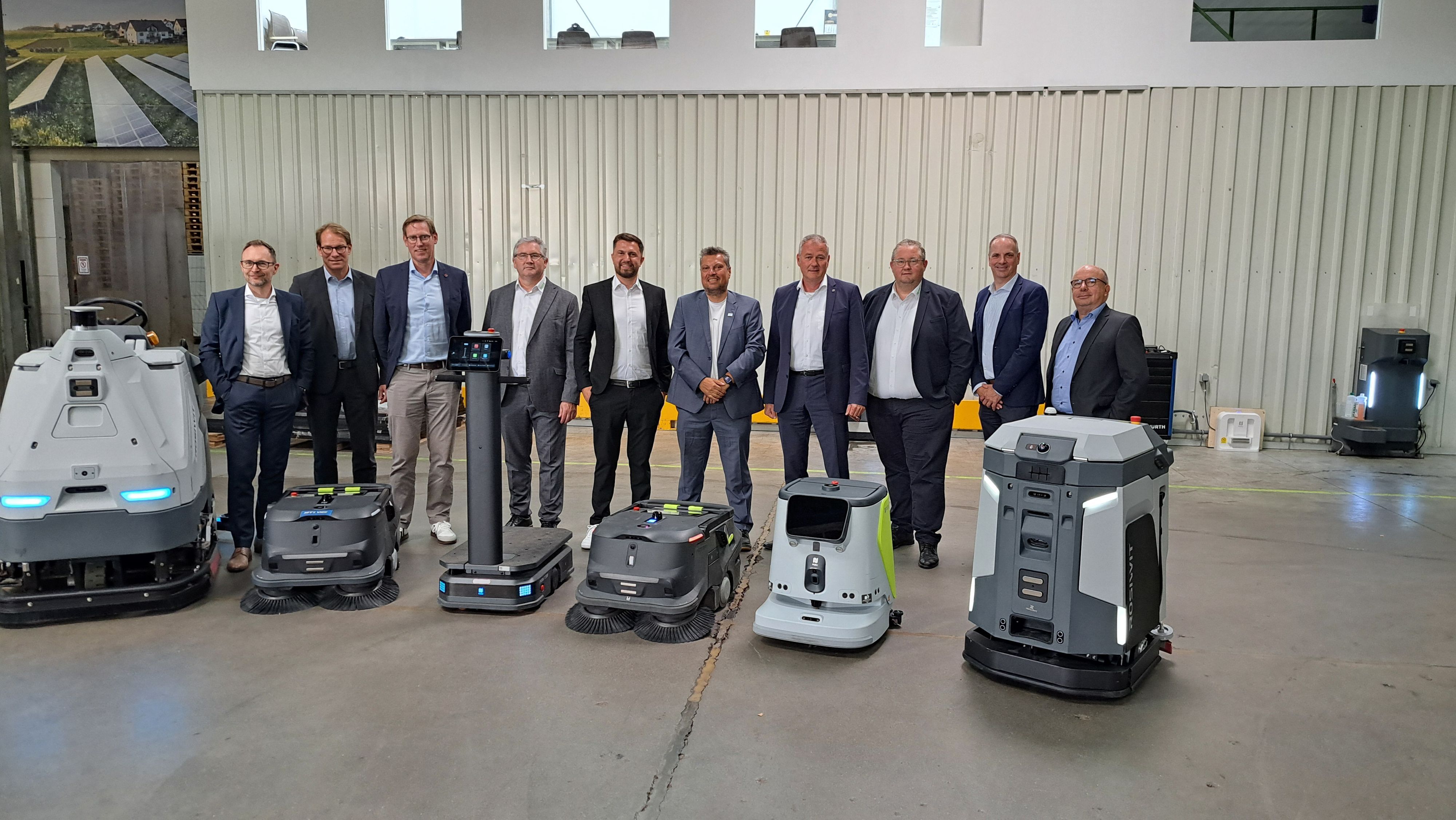 Das Foto zeigt eine Gruppe von Männern und davor einige Roboter.
