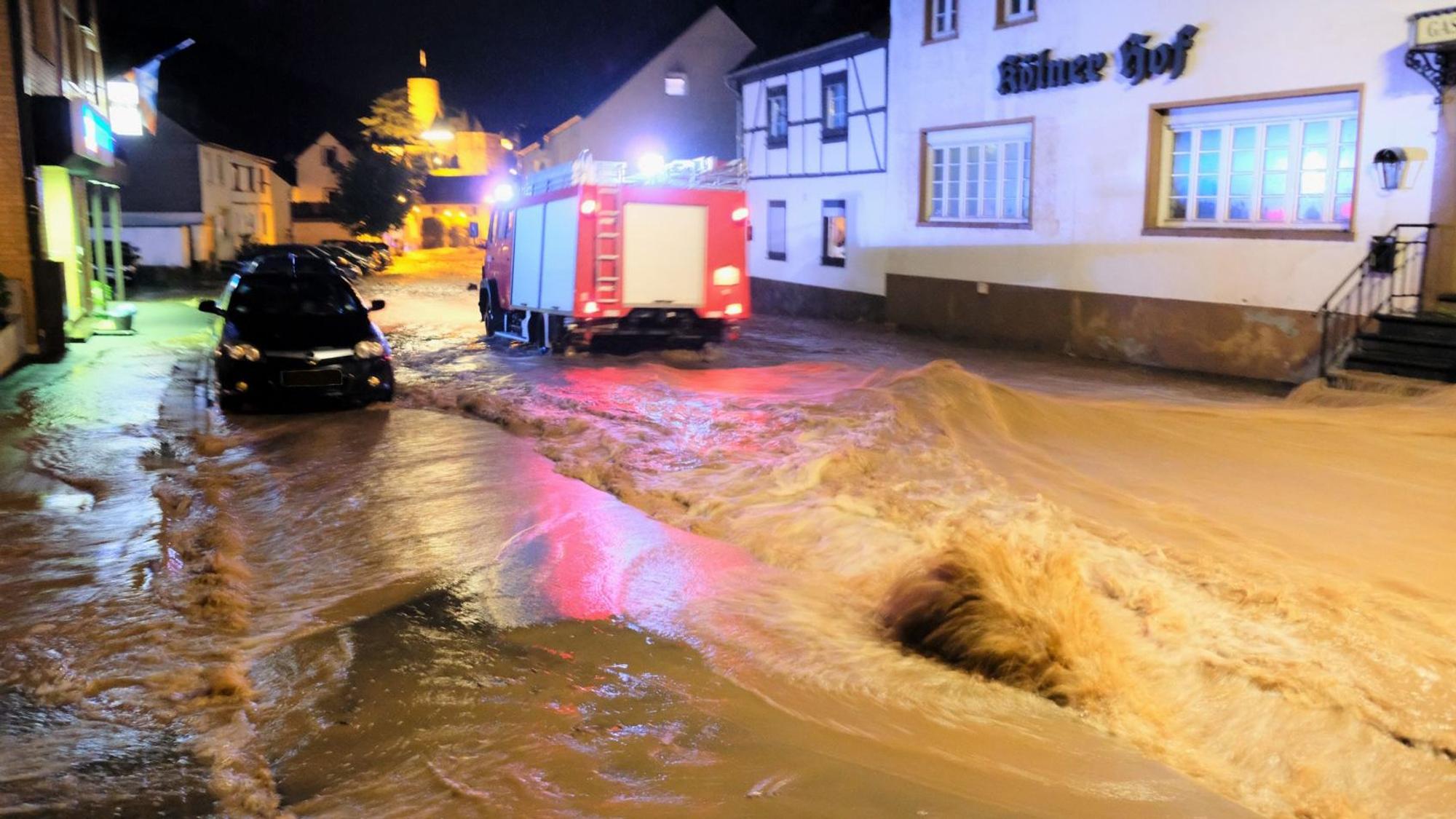 Über die Hengebachstraße schoss die Flut im Juli 2021 in die Heimbacher Innenstadt. Ein Feuerwehrfahrzeug fährt durch das Wasser.