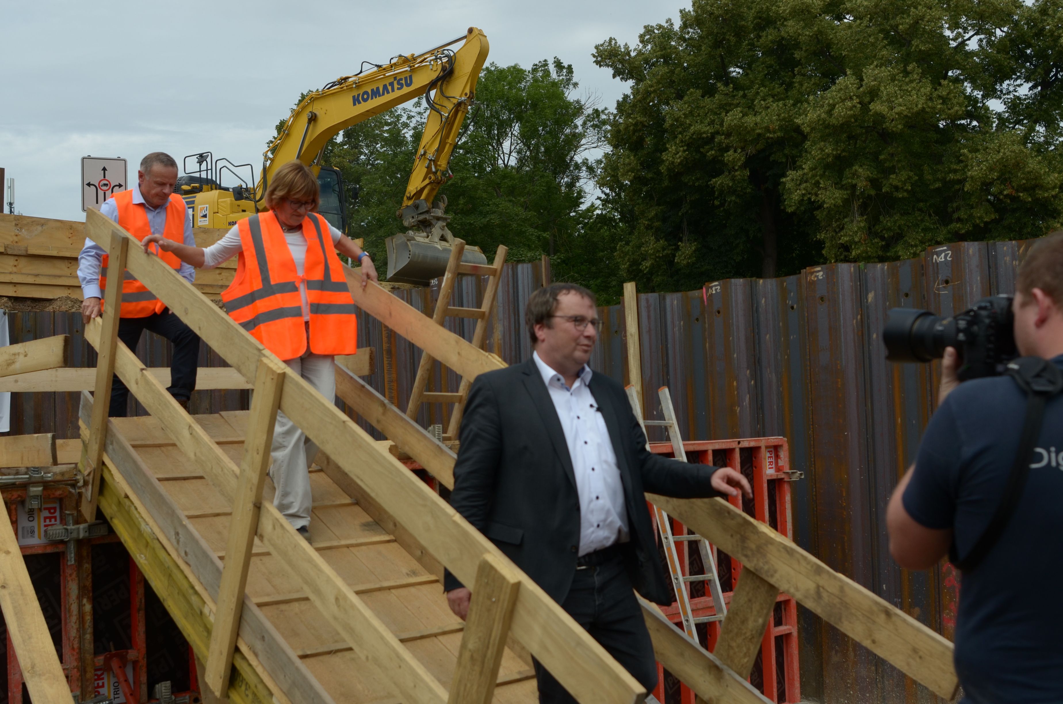 Krischer geht auf der Baustelle über eine Holzbrücke.