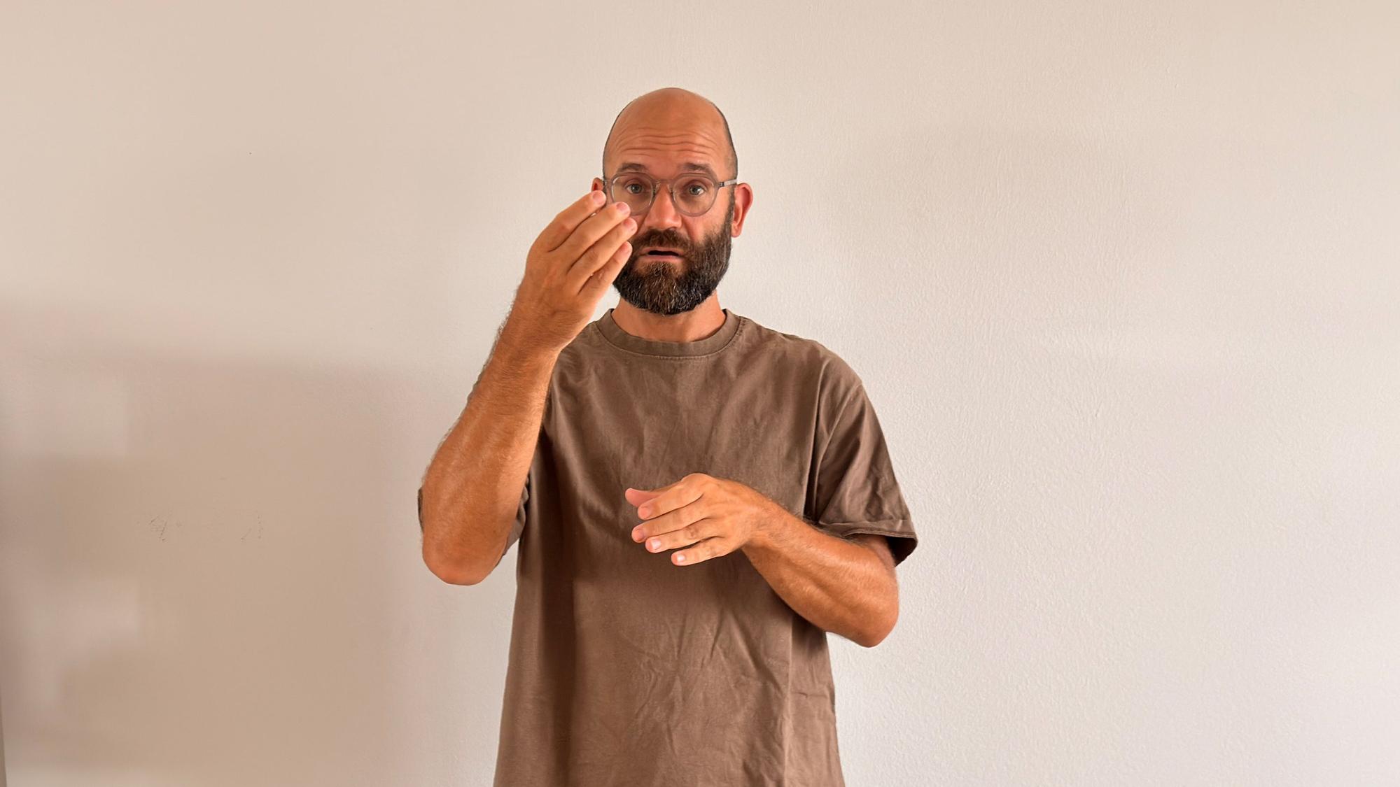 Auf dem Bild ist ein Gebärdendolmetscher zu sehen.