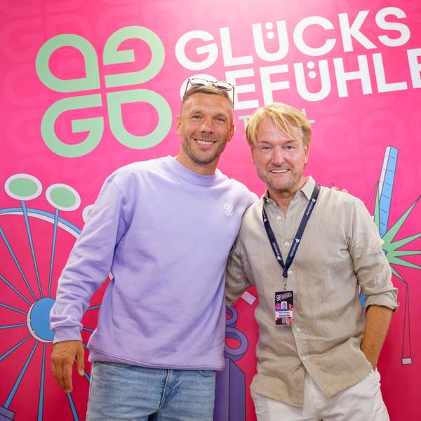 Der Fußballspieler Lukas Podolski (l.) und Musikmanager Markus Krampe stehen auf dem Hockenheimring während einer Pressekonferenz vor einem Logo des Glücksgefühle-Festivals. (Archivbild)