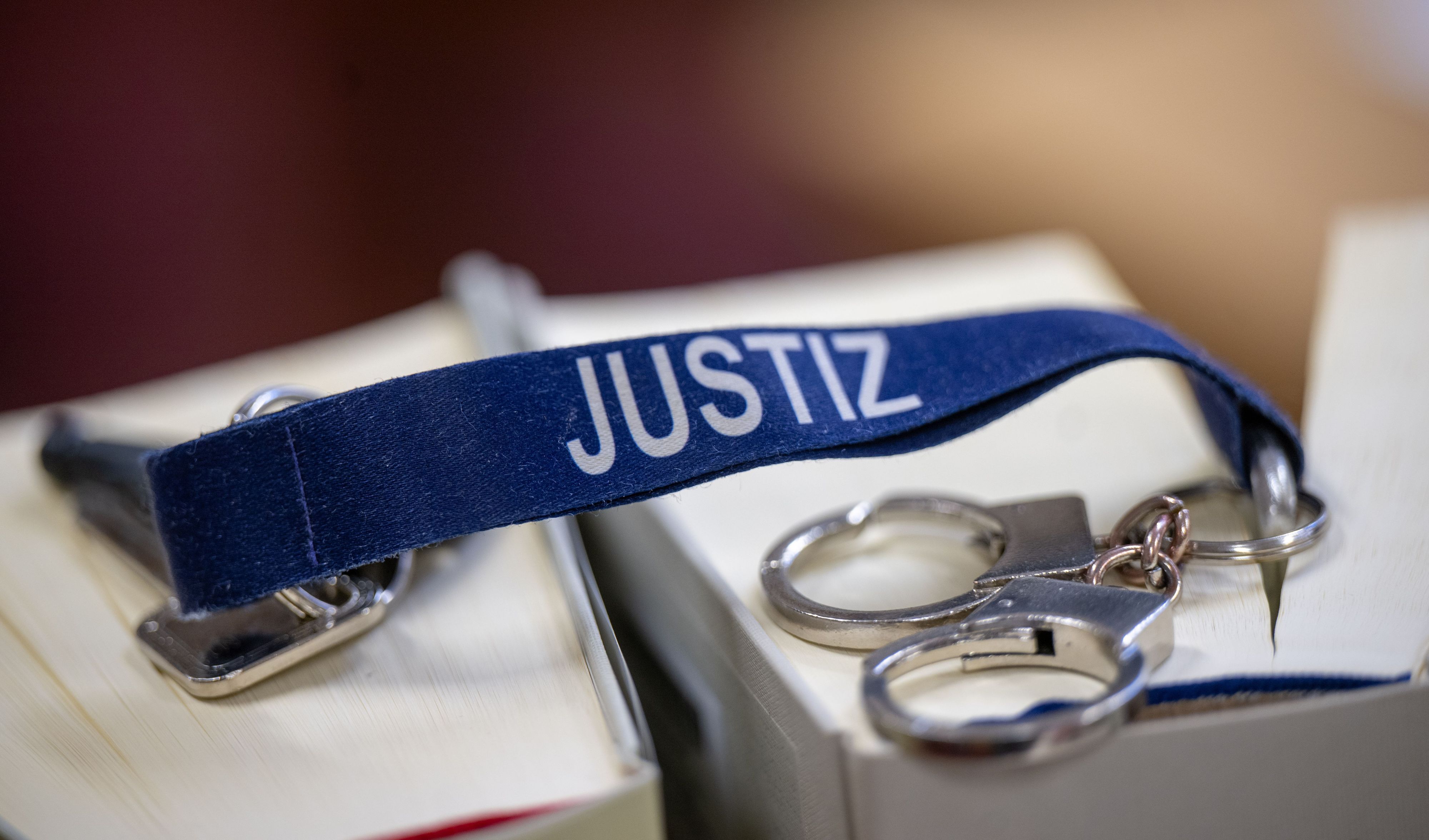 Ein blauer Schlüsselanhänger mit weißer Aufschrift Justiz