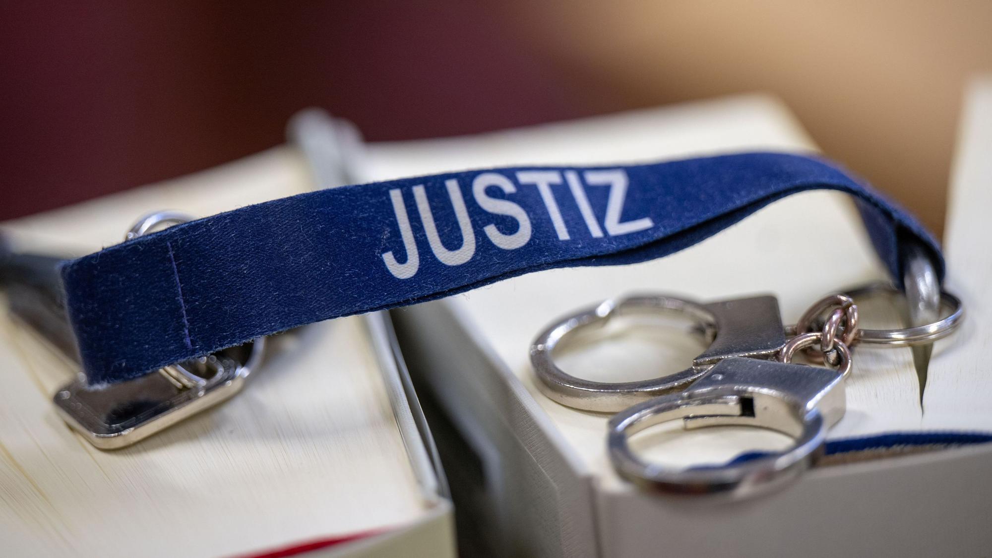 Ein blauer Schlüsselanhänger mit weißer Aufschrift Justiz