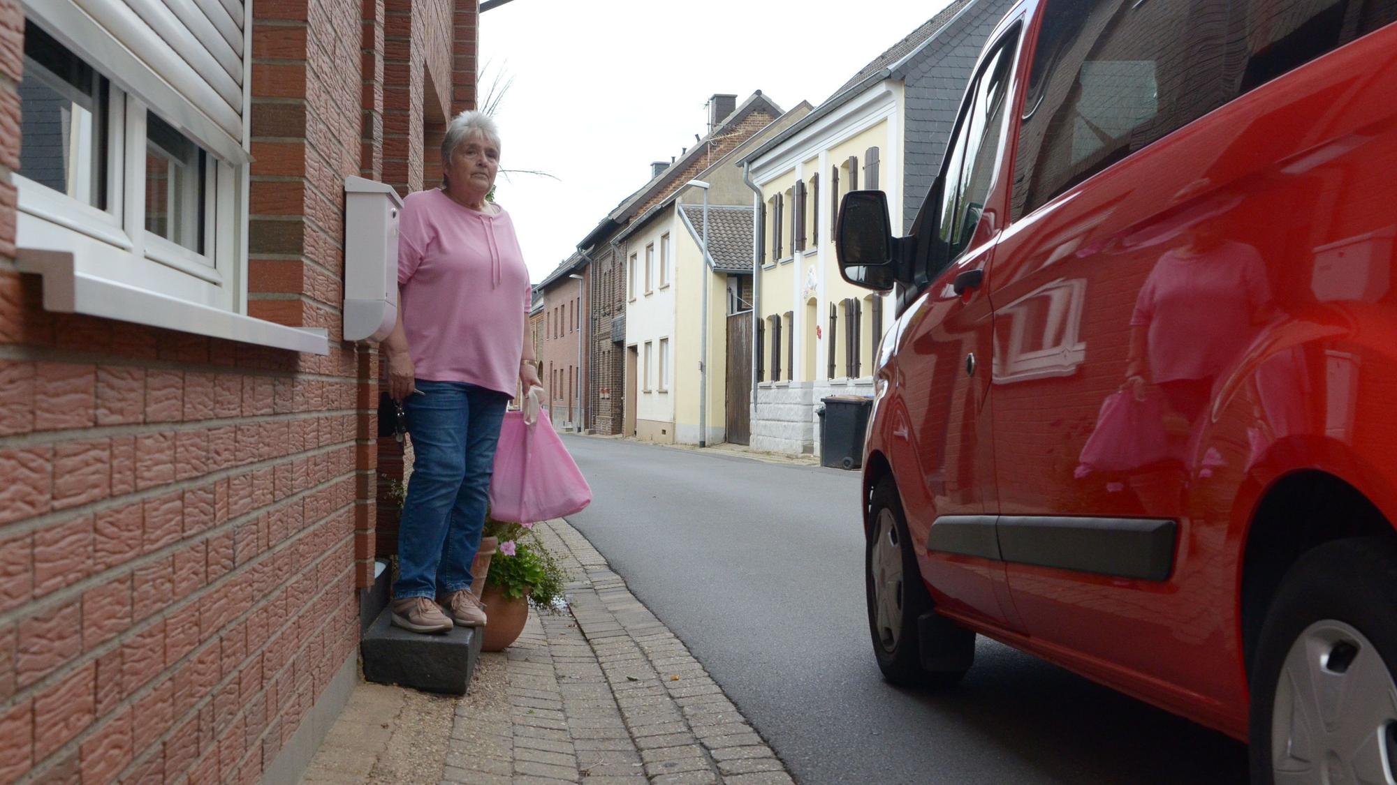 Ute Hunkirchen steht auf der einstufigen Treppe. Ein vorbeifahrendes Auto ist nur geschätzt einen Meter von ihr entfernt.