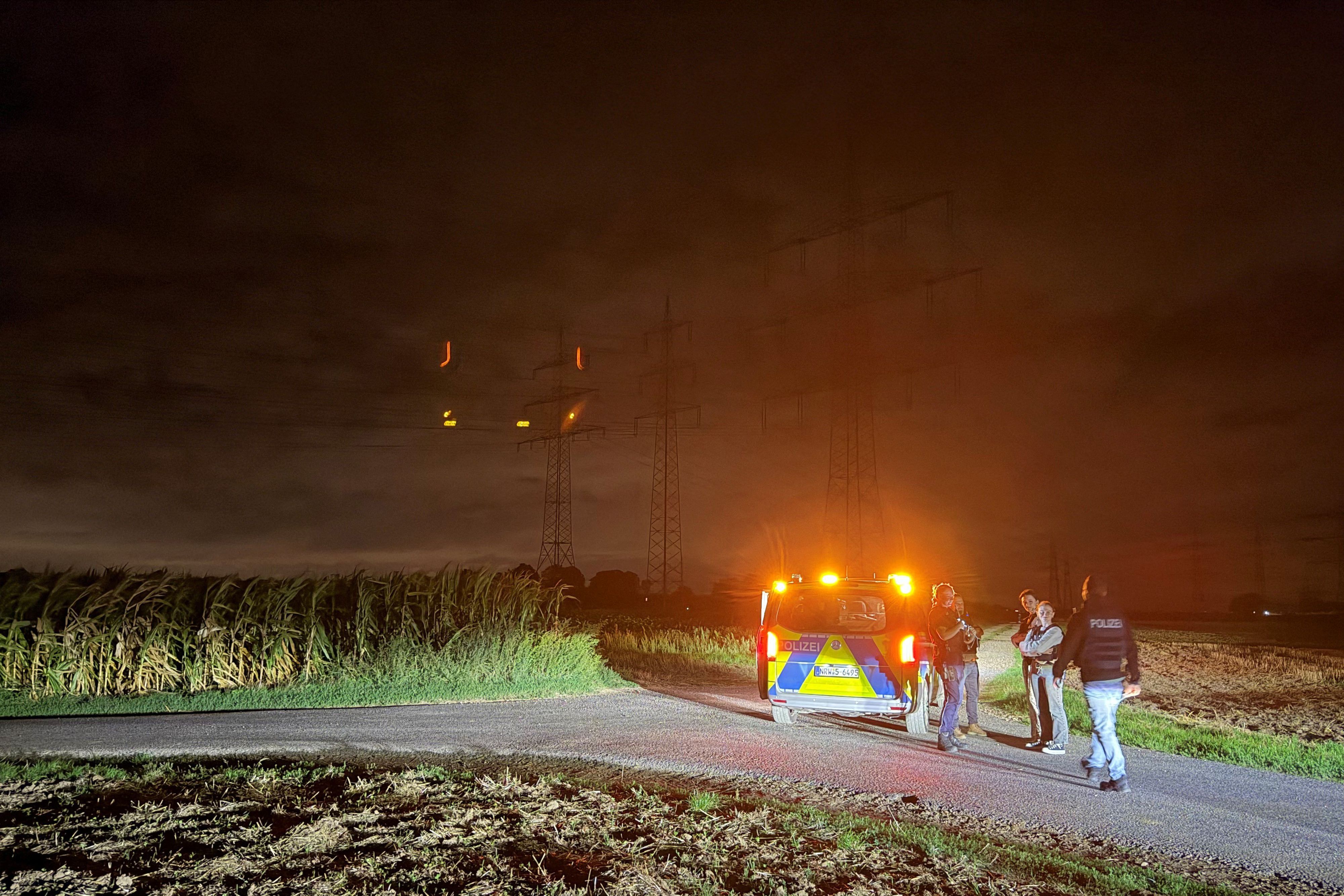Polizisten stehen in der Nähe eines Umspannwerks.