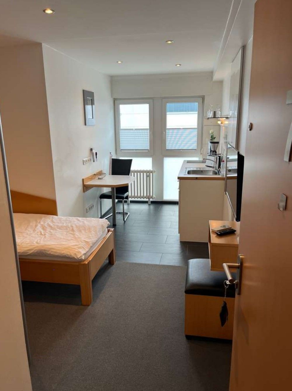 Blick in einen Raum, in dem ein Bett und eine Spüle sind.