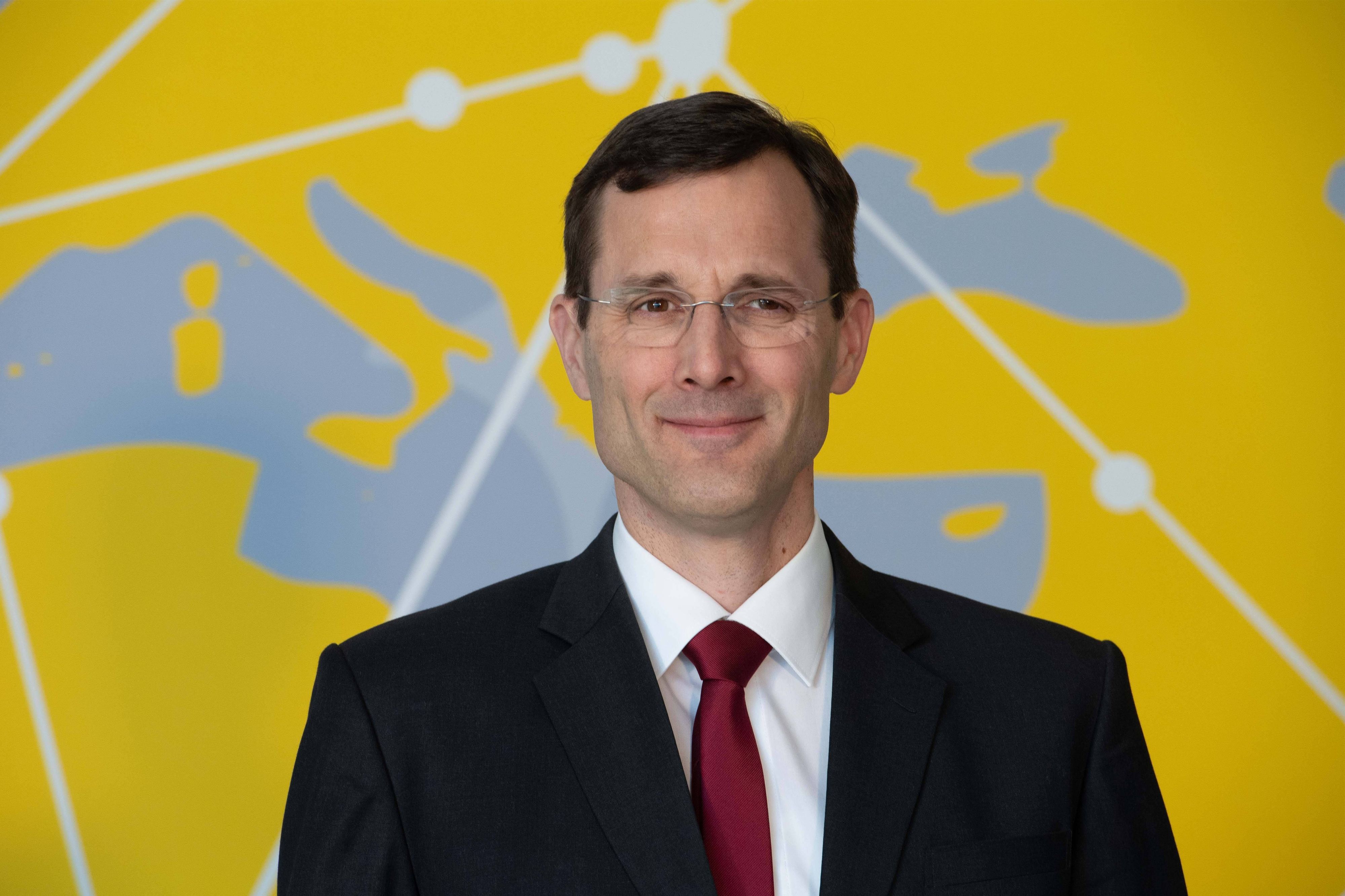 Dr. Tobias Meyer ist im Halbporträt zu sehen - er lächelt in die Kamera.
