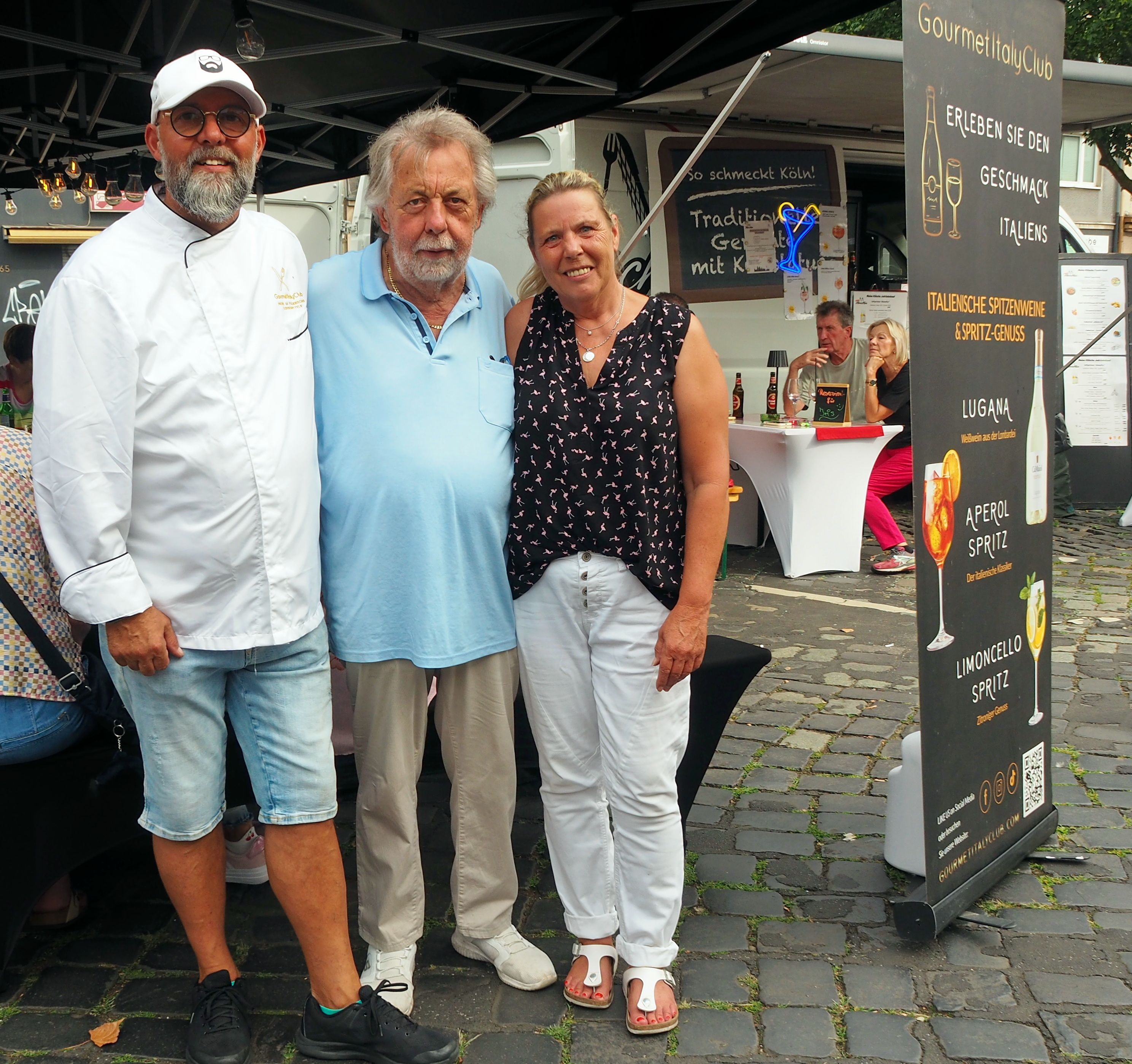 Umberto Mazza, Wolfgang Kaus und Beate Braun – sie war jetzt zum zweiten Mal mit „Meine kölsche Küche“ auf dem Zollstocker Schlemmermarkt vertreten – sind mit der Zollstocker Veranstaltung zufrieden, machen sich aber Sorgen wegen der zunehmenden Hitze im Sommer.