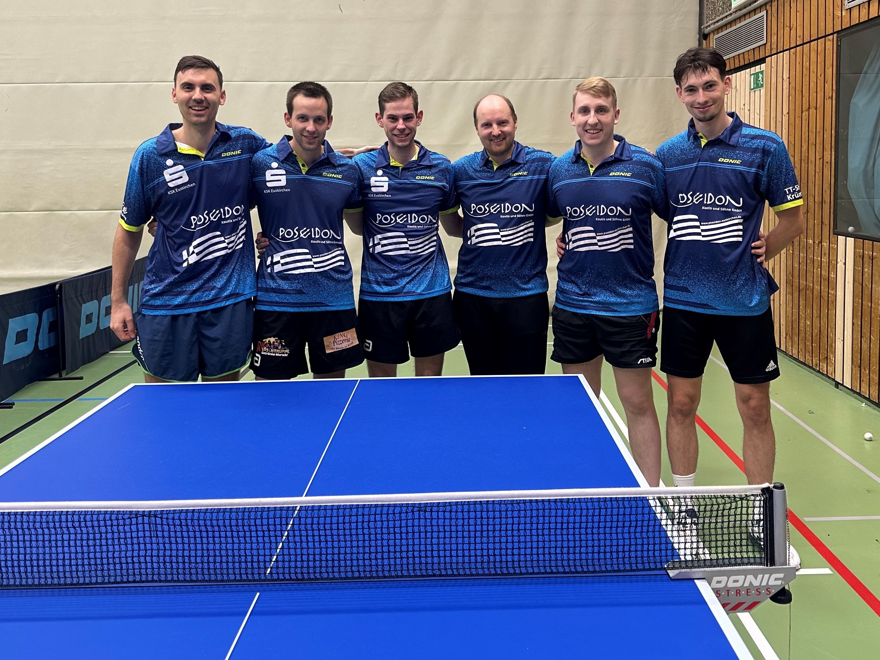 Sechs Tischtennisspieler stehen Arm in Arm hinter einer Platte.