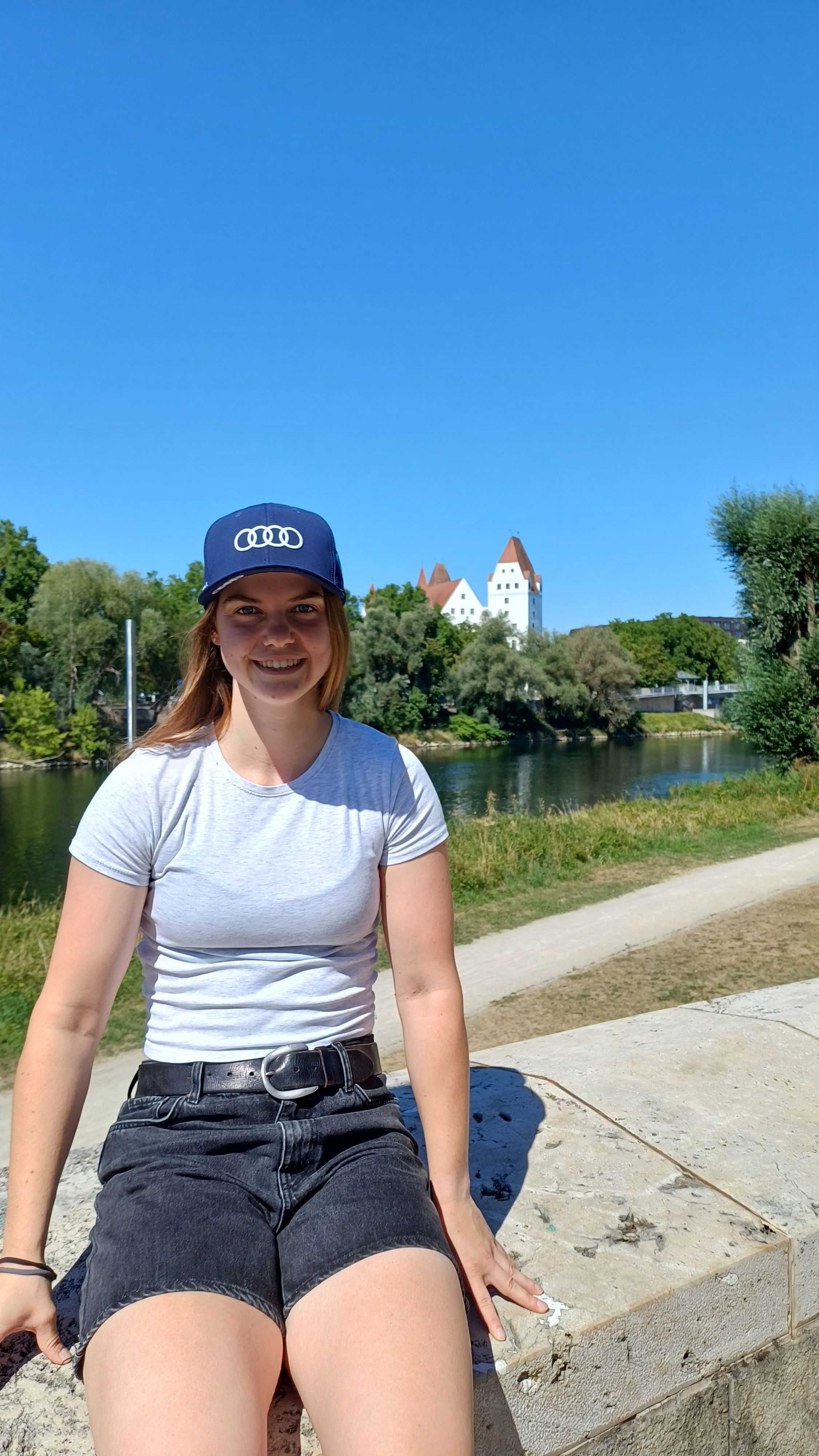 Naemi Bär sitzt auf einer Mauer.