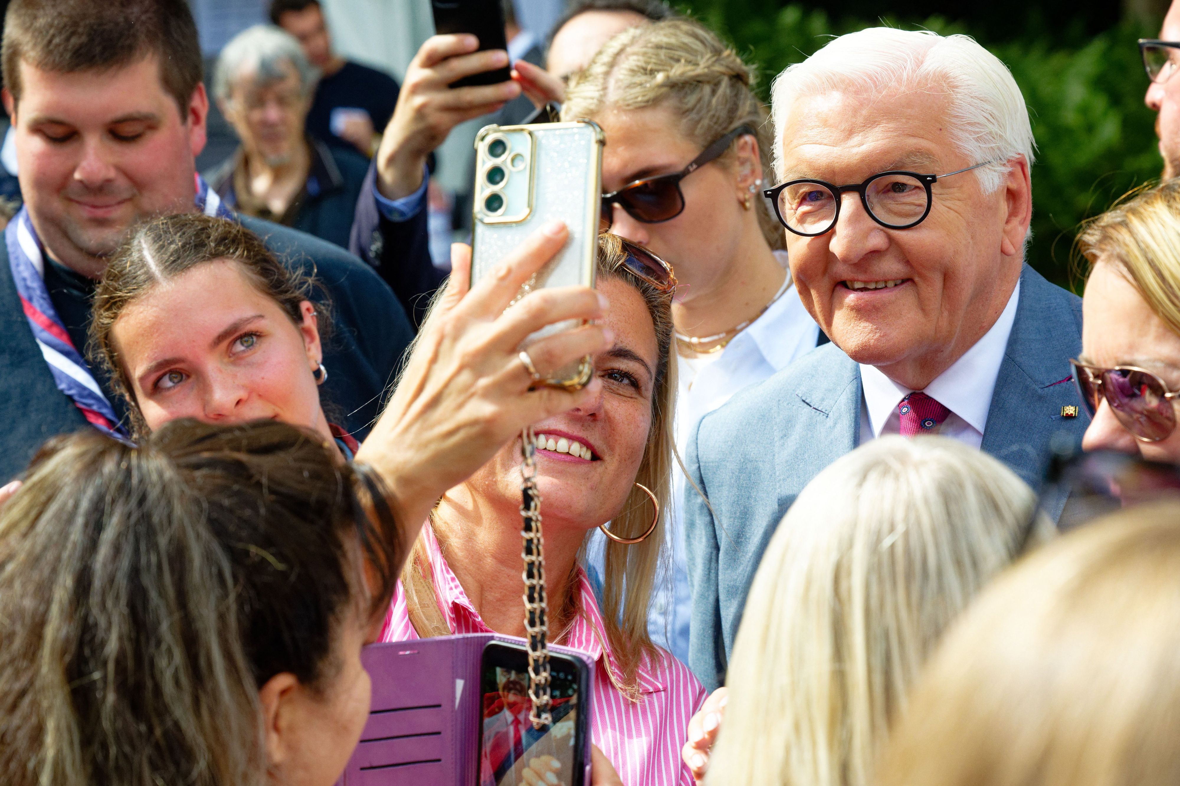Bundespräsident Frank-Walter Steinmeier (r) macht beim Bürgerfest im Park der Villa Hammerschmidt in Bonn Selfies mit Besuchern.