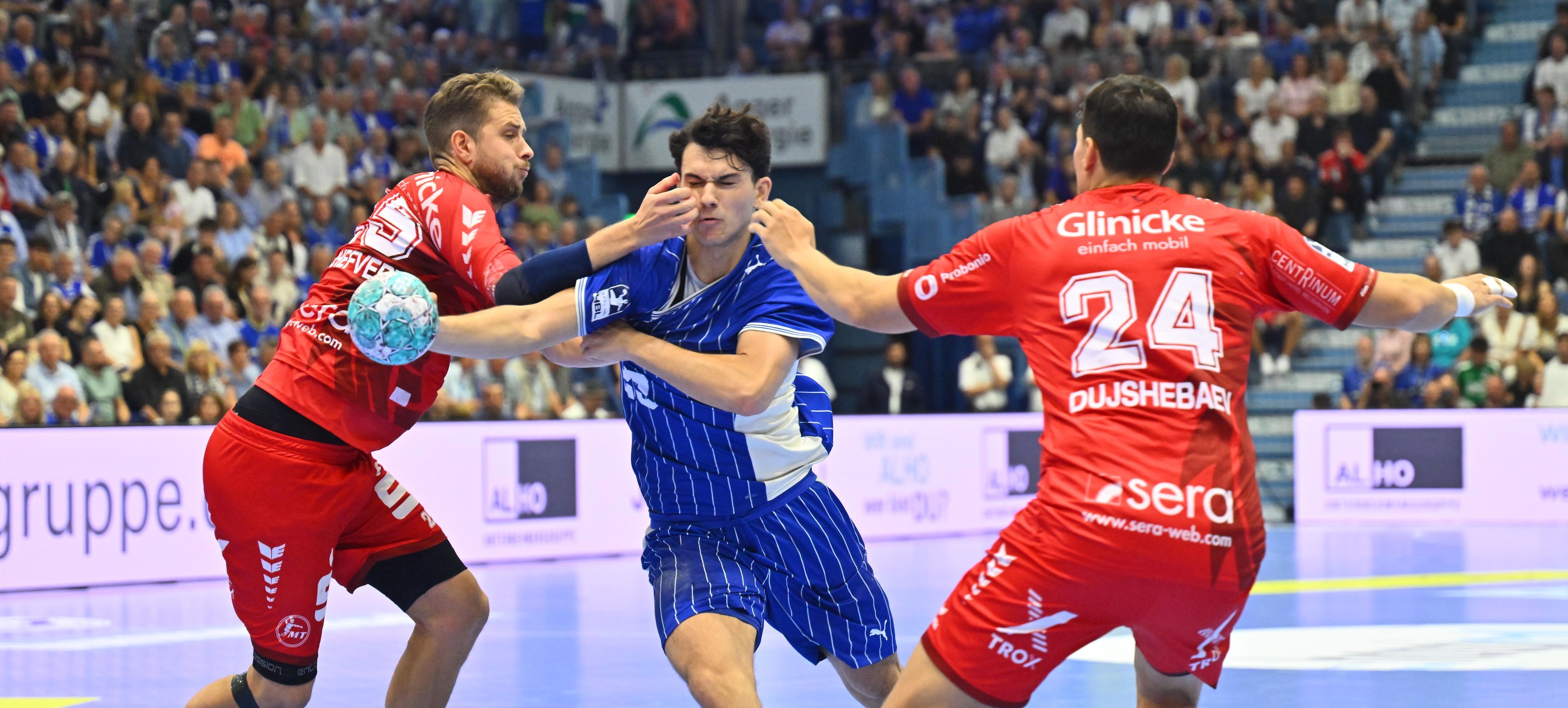 Mit dem Ball in der Hand kämpft sich Nikola Roganovic durch zwei Melsunger Abwehrspieler.