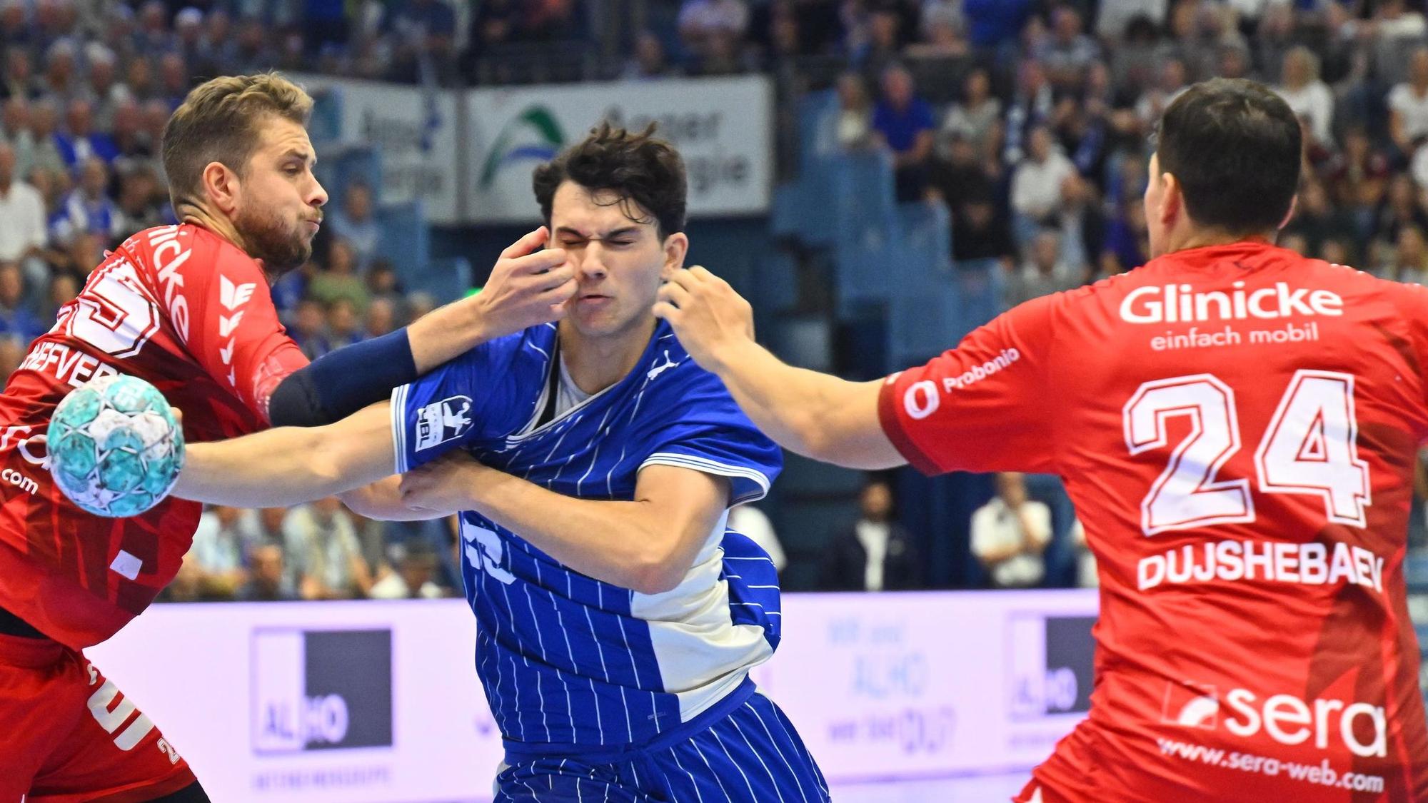 Mit dem Ball in der Hand kämpft sich Nikola Roganovic durch zwei Melsunger Abwehrspieler.
