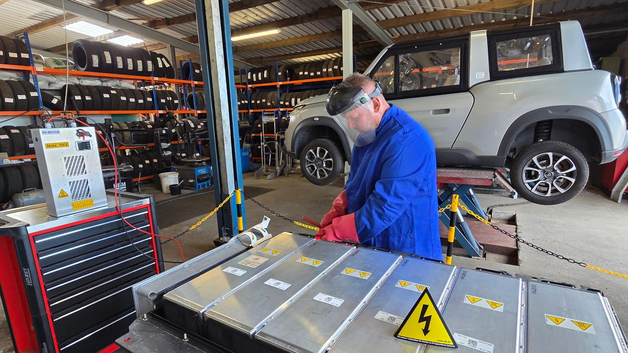 René Fauré, Mitarbeiter der Autoverwertung und des Schrotthandels Noiron von Michael Kappenstein, entlädt die Batterie des Citroën Méhari, der in Waldbröl zerlegt wird. Die Teile werden dann verkauft
