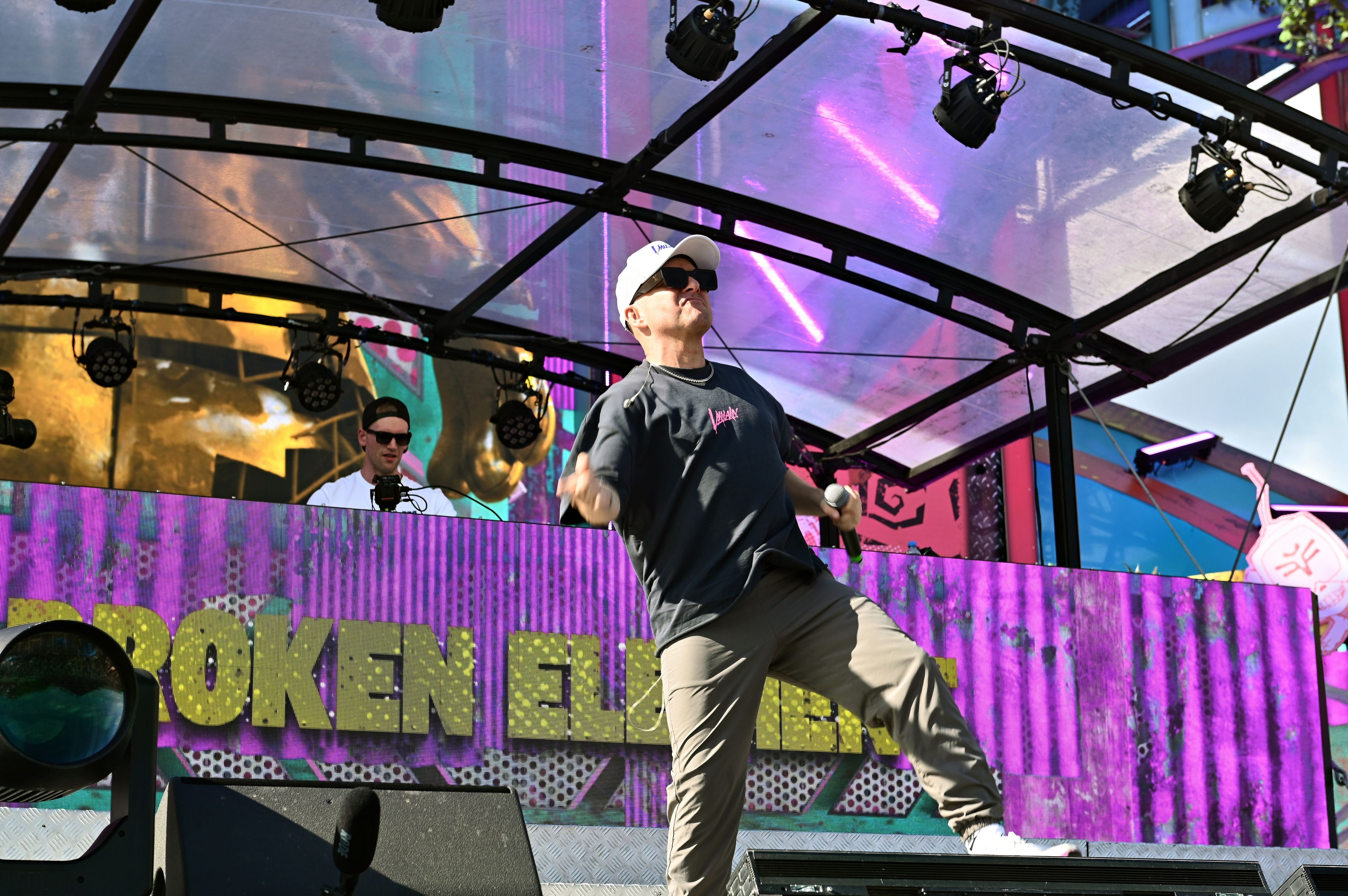 Joel Thienelt, mit Sonnenbrille und weißer Kappe, animiert das Publikum zum Tanzen.