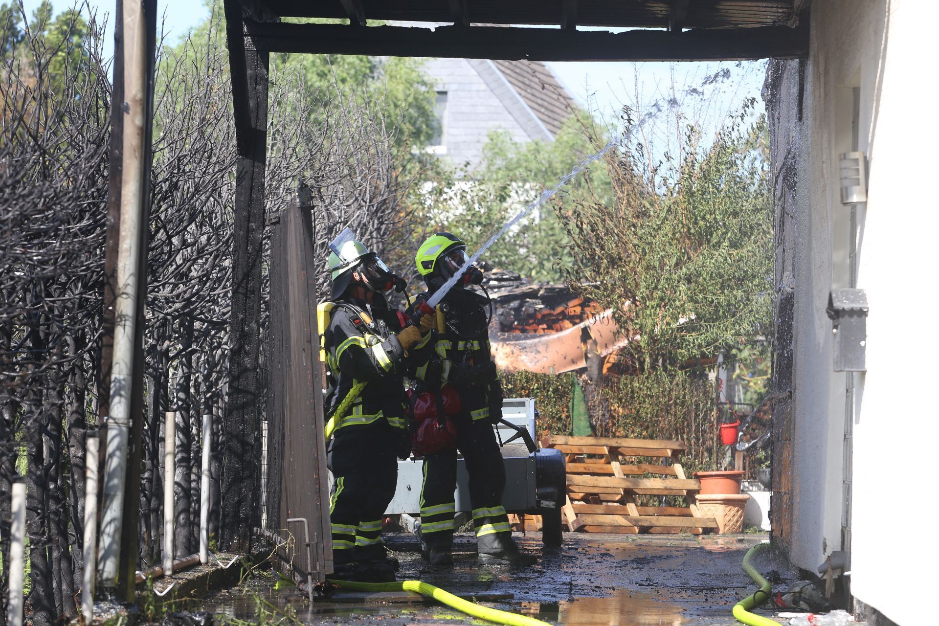 Feuerwehrleute im Einsatz mit einem Löschschlauch.