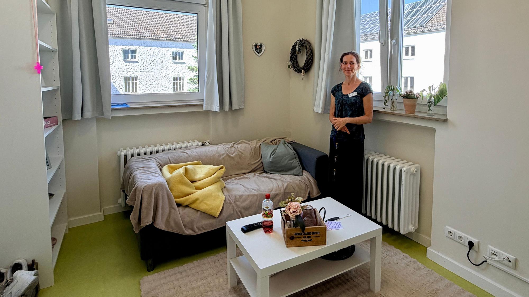 Das Bild zeigt einen Blick in ein Bewohnerzimmer. Zu sehen sind ein Sofa, ein Tisch und ein Regal.