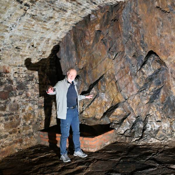 Norbert Liebing steht im alten Felsenkeller in Bad Münstereifel und hat die Arme ausgebreitet.