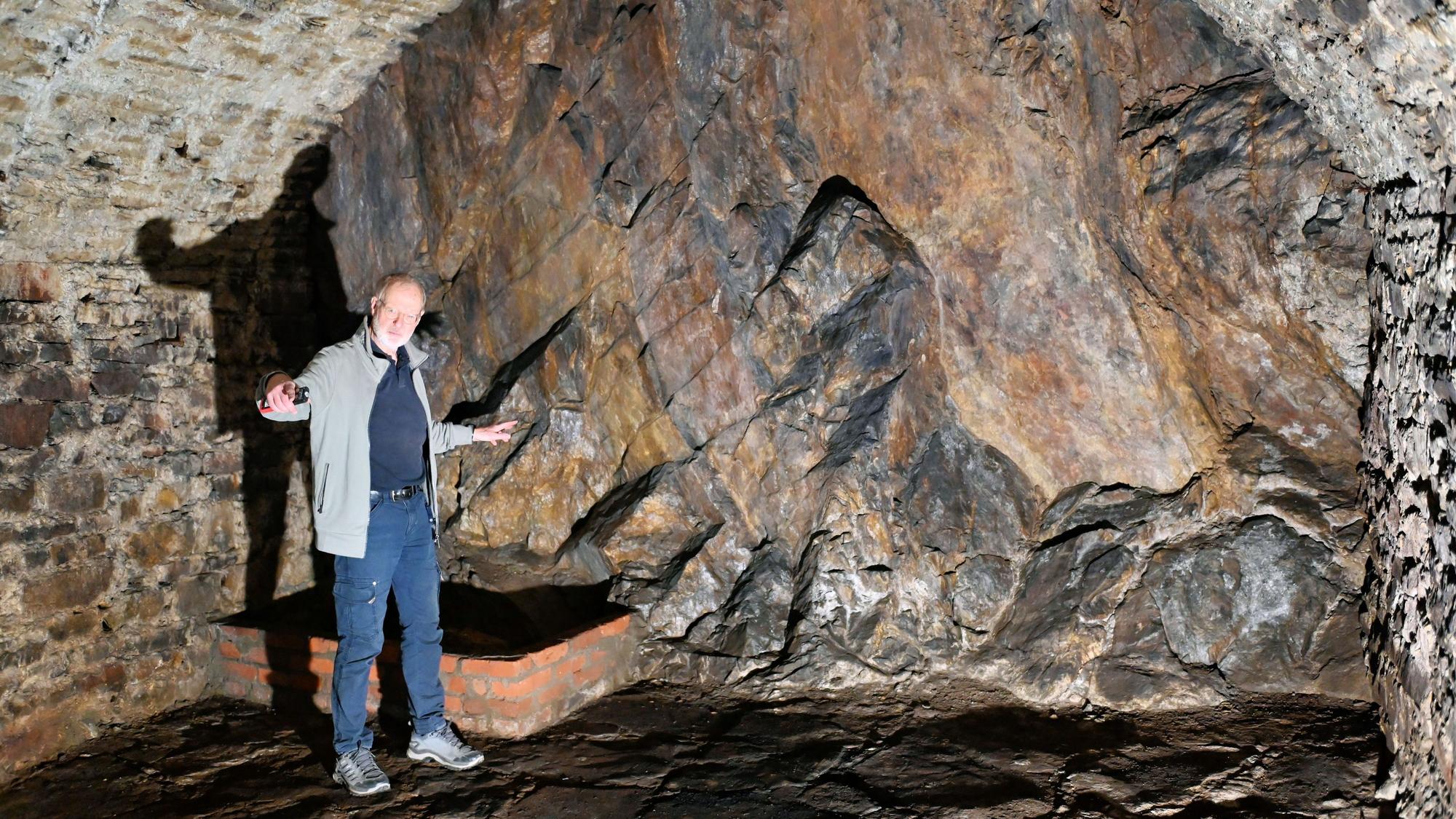 Norbert Liebing steht im alten Felsenkeller in Bad Münstereifel und hat die Arme ausgebreitet.