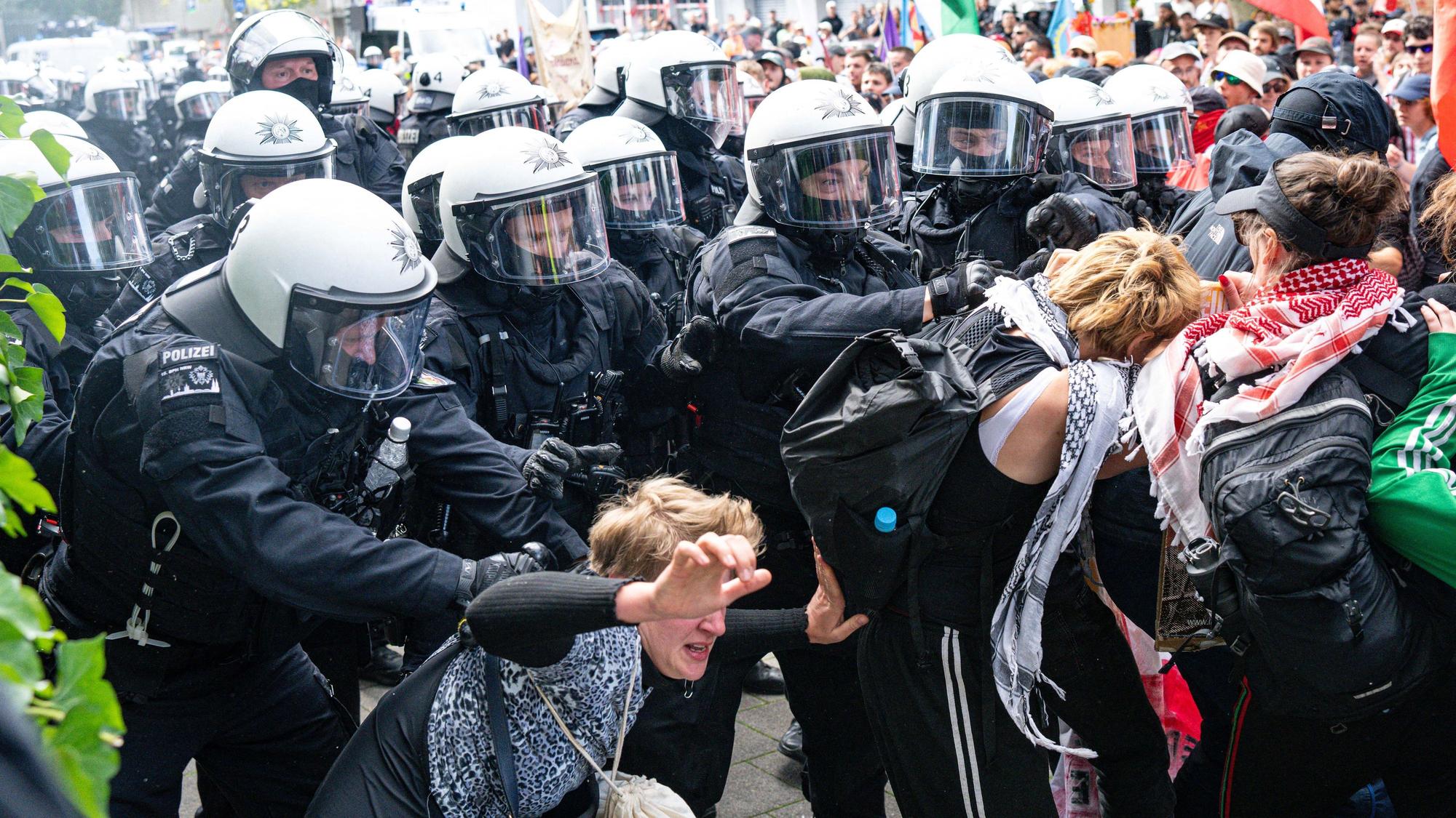 Bei der Abschlussdemonstration des Protestcamps "Rheinmetall entwaffnen" werden Teilnehmer der Demo von Polizisten weggedrängt.