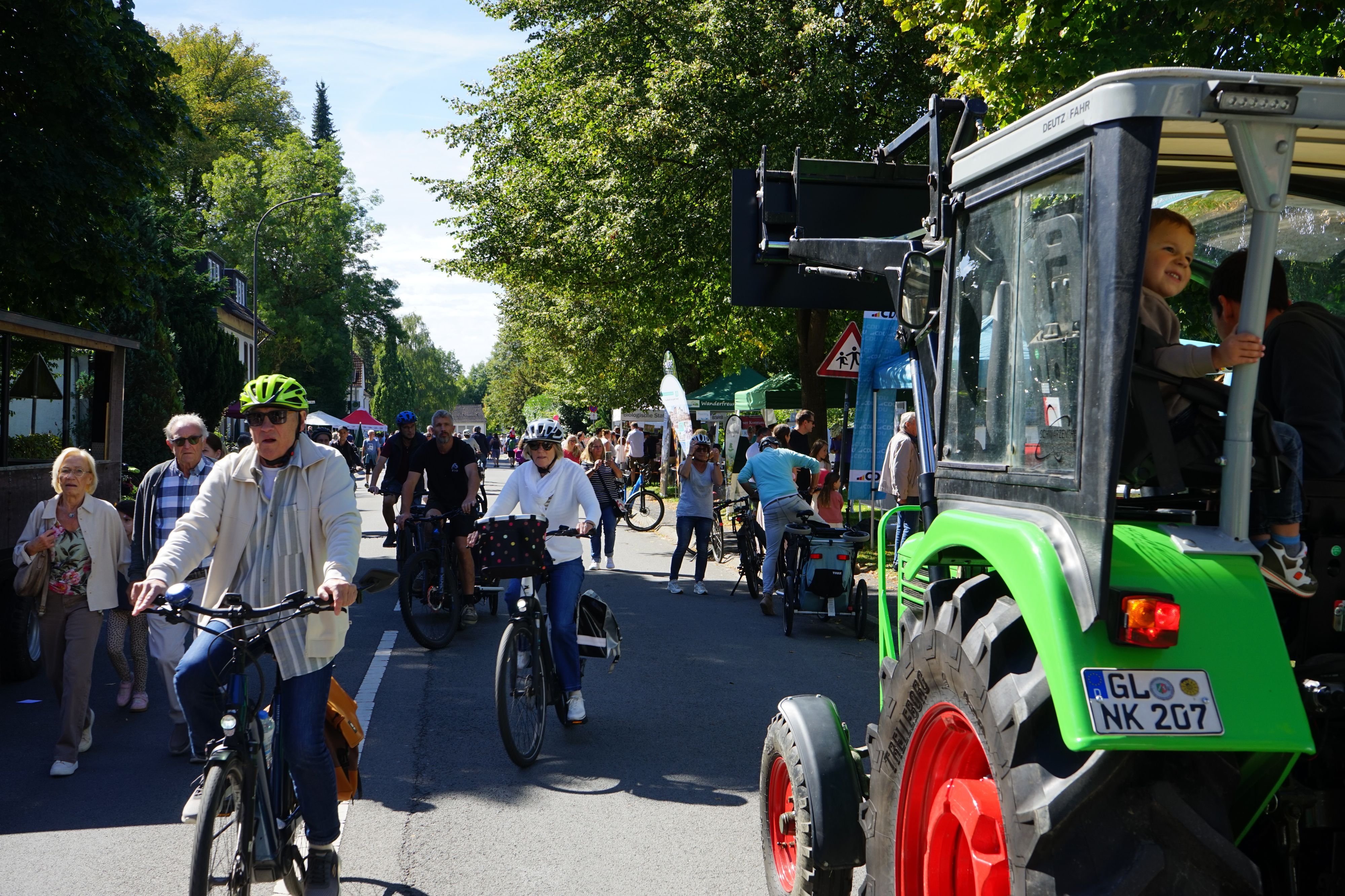 Fahrradfahrer und Fußgänger gehen in Herrenstrunden über die gesperrte Landstraße.