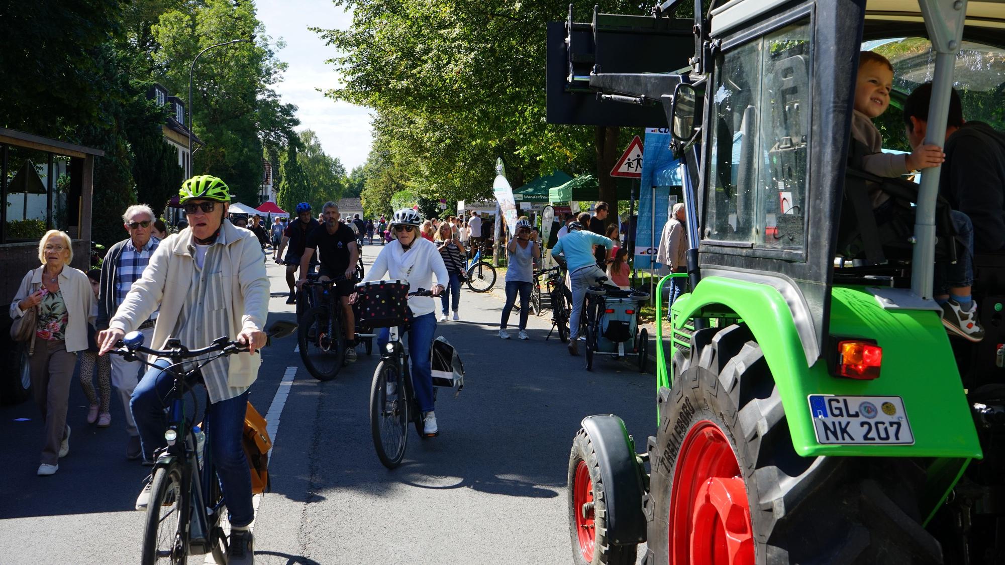 Fahrradfahrer und Fußgänger gehen in Herrenstrunden über die gesperrte Landstraße.