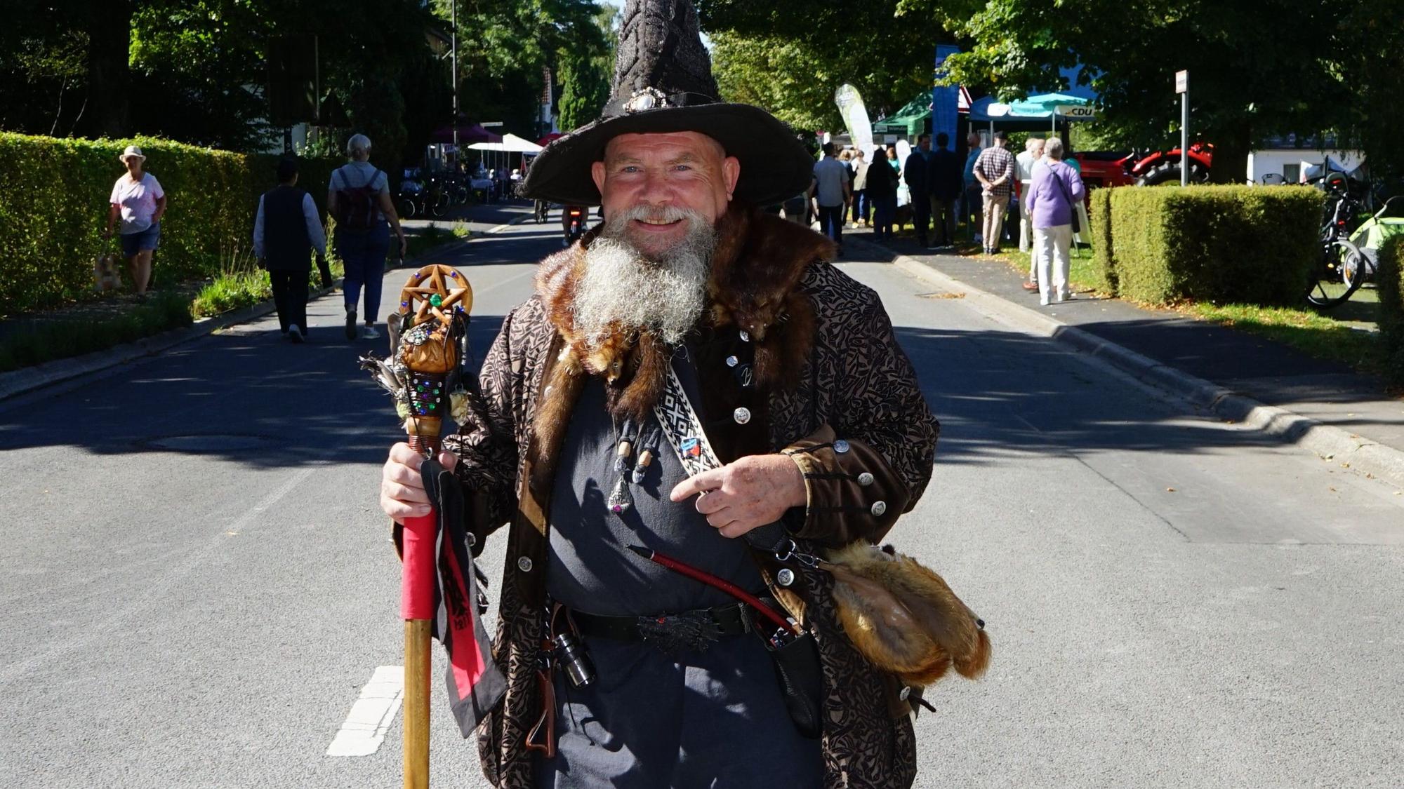 Zauberer Merlin steht auf der Straße in Herrenstrunden.