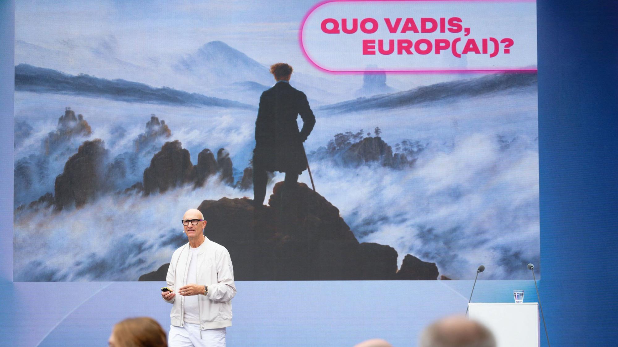 Der CEO der Deutschen Telekom, Timotheus Höttges, spricht auf der Digitalmesse Digital X vor einem Bild von Caspar David Friedrich: Wanderer über dem Nebelmeer