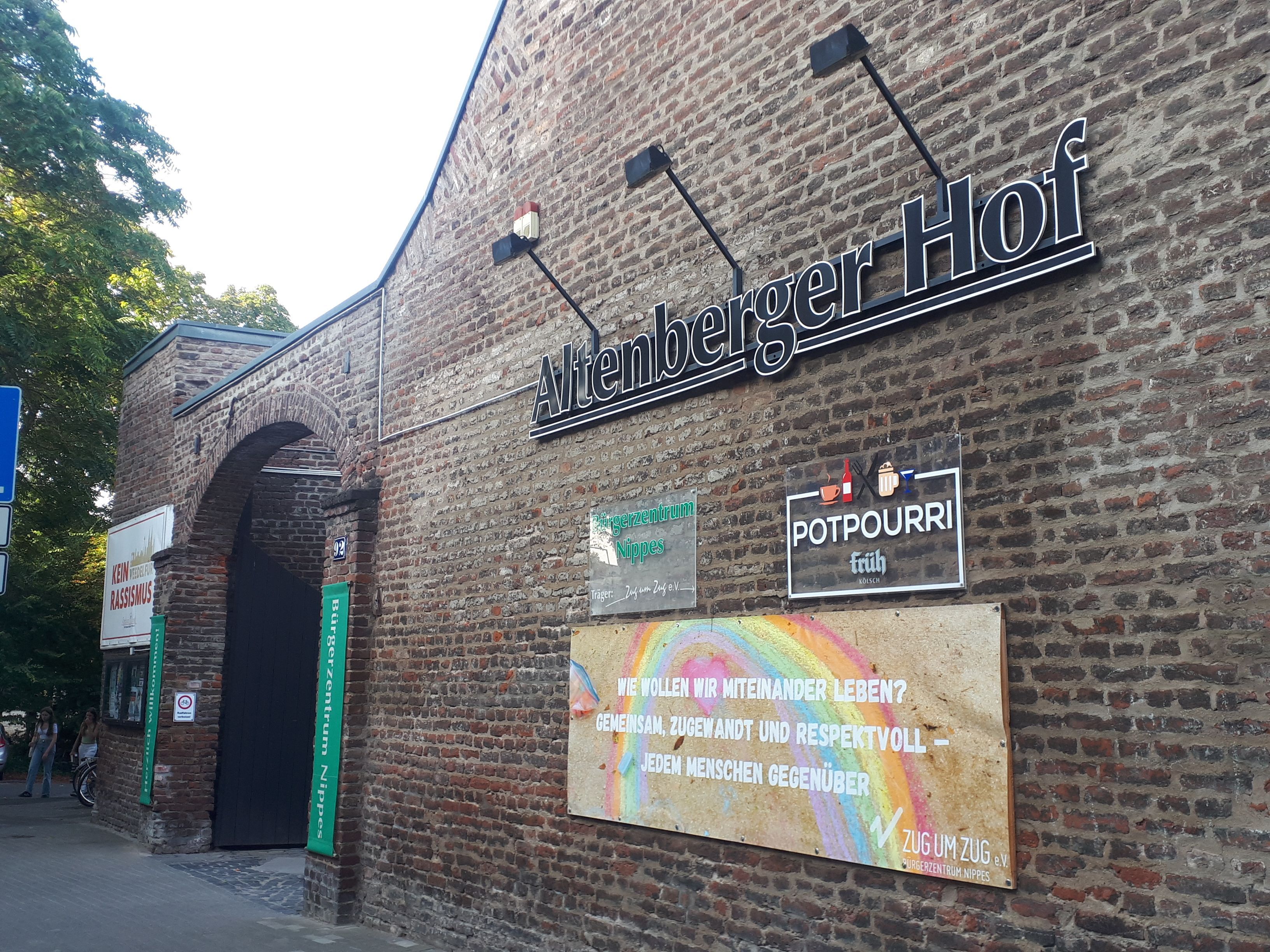 An der Ziegelwand eines Gutshofs hängt der Schriftzug Altenberger Hof.