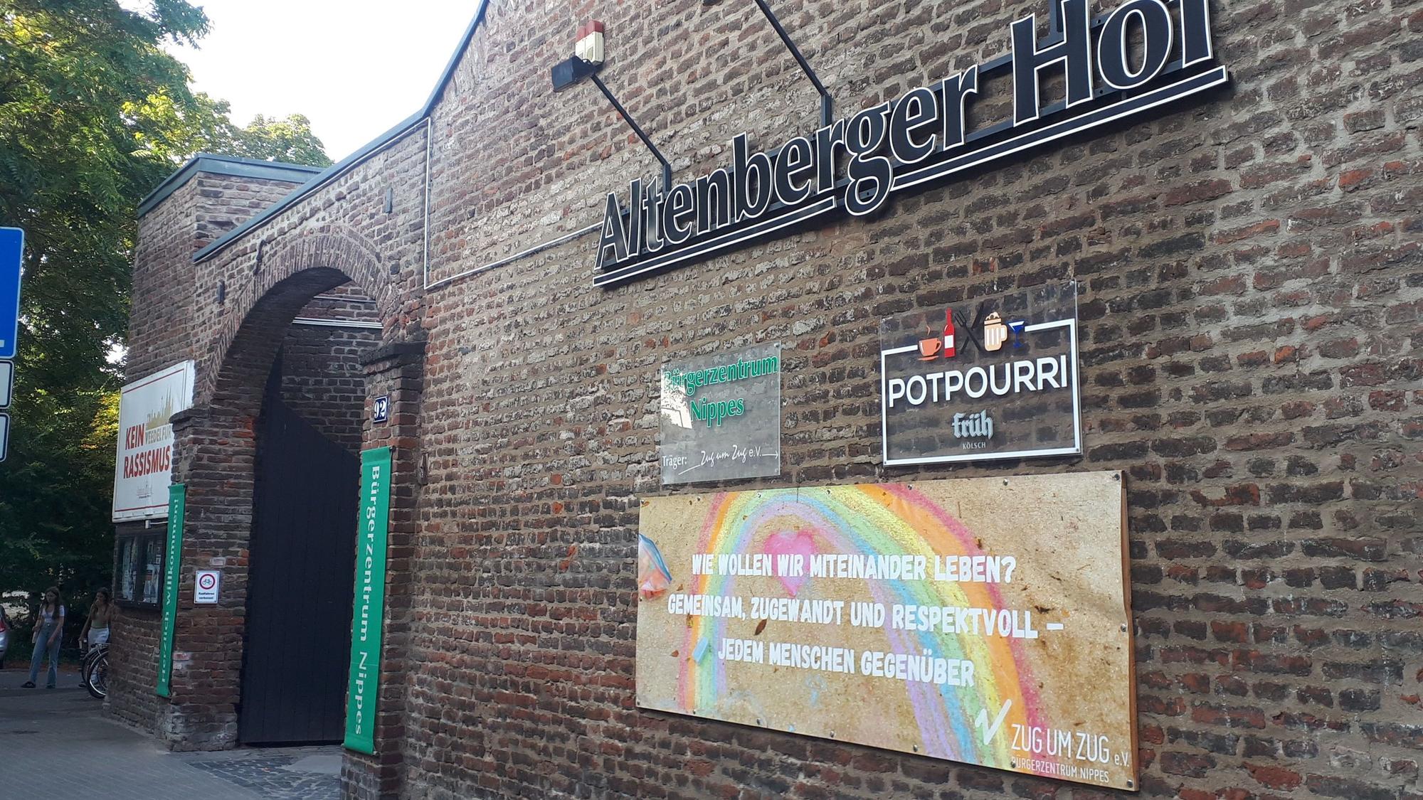 An der Ziegelwand eines Gutshofs hängt der Schriftzug Altenberger Hof.