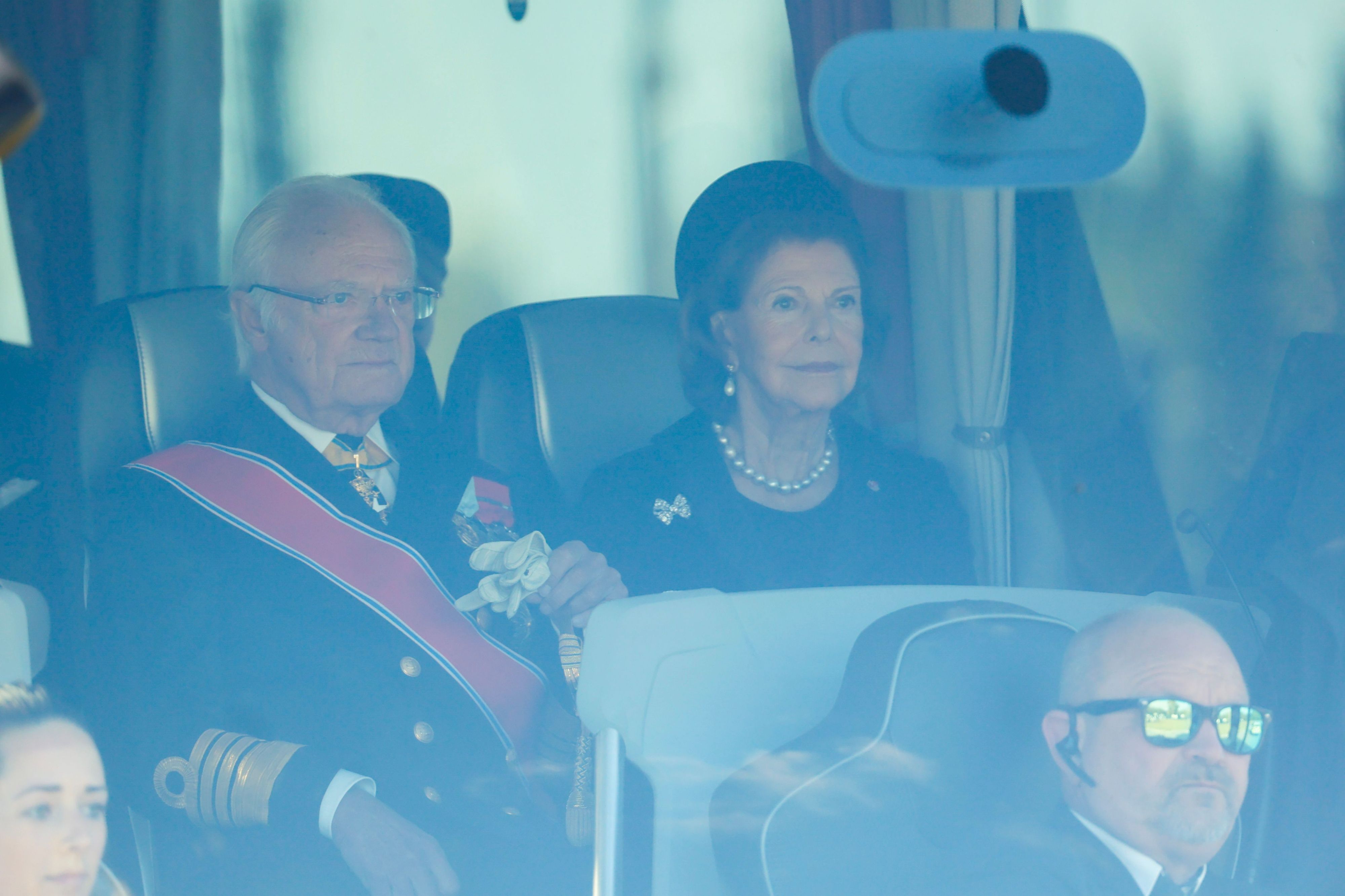 Der schwedische König Carl Gustaf und Königin Silvia sitzen in einem Bus am Flughafen Oslo bei ihrer Ankunft zur Beisetzung von König Harald V.