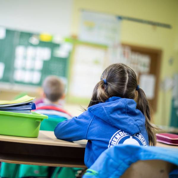 Schülerinnen und Schüler einer Grundschule sitzen in ihrem Klassenraum.