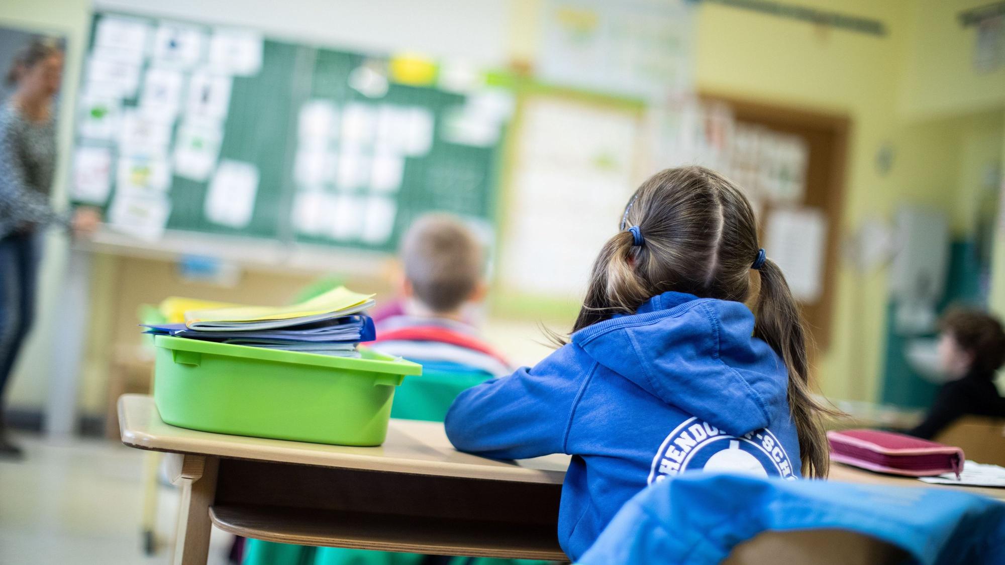 Schülerinnen und Schüler einer Grundschule sitzen in ihrem Klassenraum.