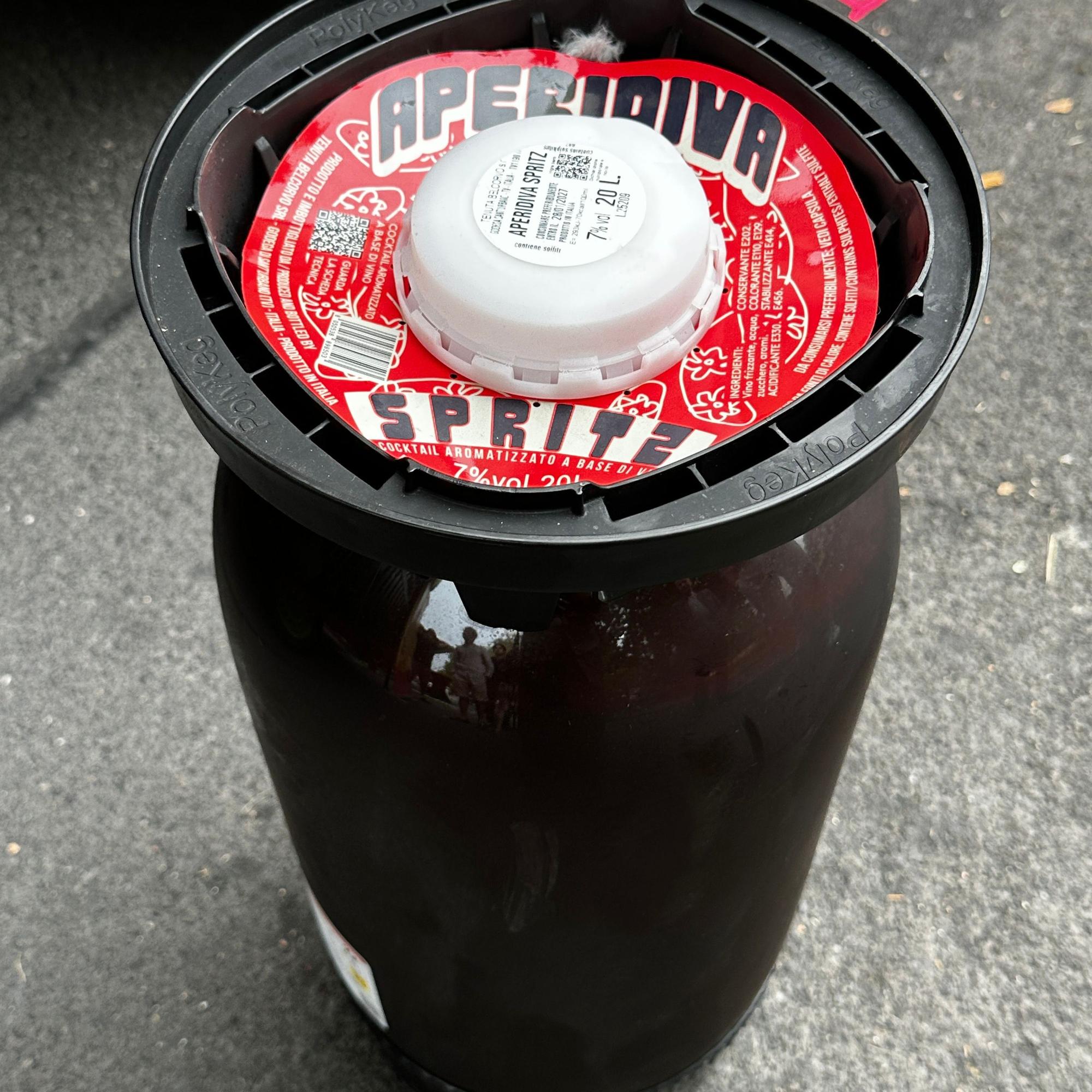 Ein großes dunkles Fass trägt die Aufschrift „Aperidiva Spritz“.
