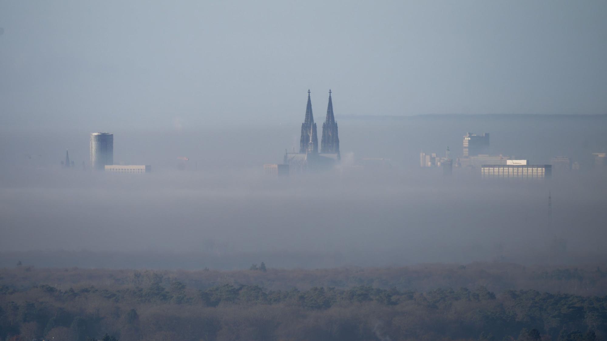 Der Dom und andere hohe Häuser ragen aus dem Nebel über Köln. (Archivbild)