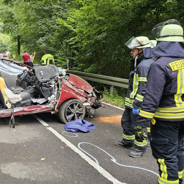 Ein Autowrack steht auf der Dürschtalstraße, Feuerwehrleute stehen daneben.