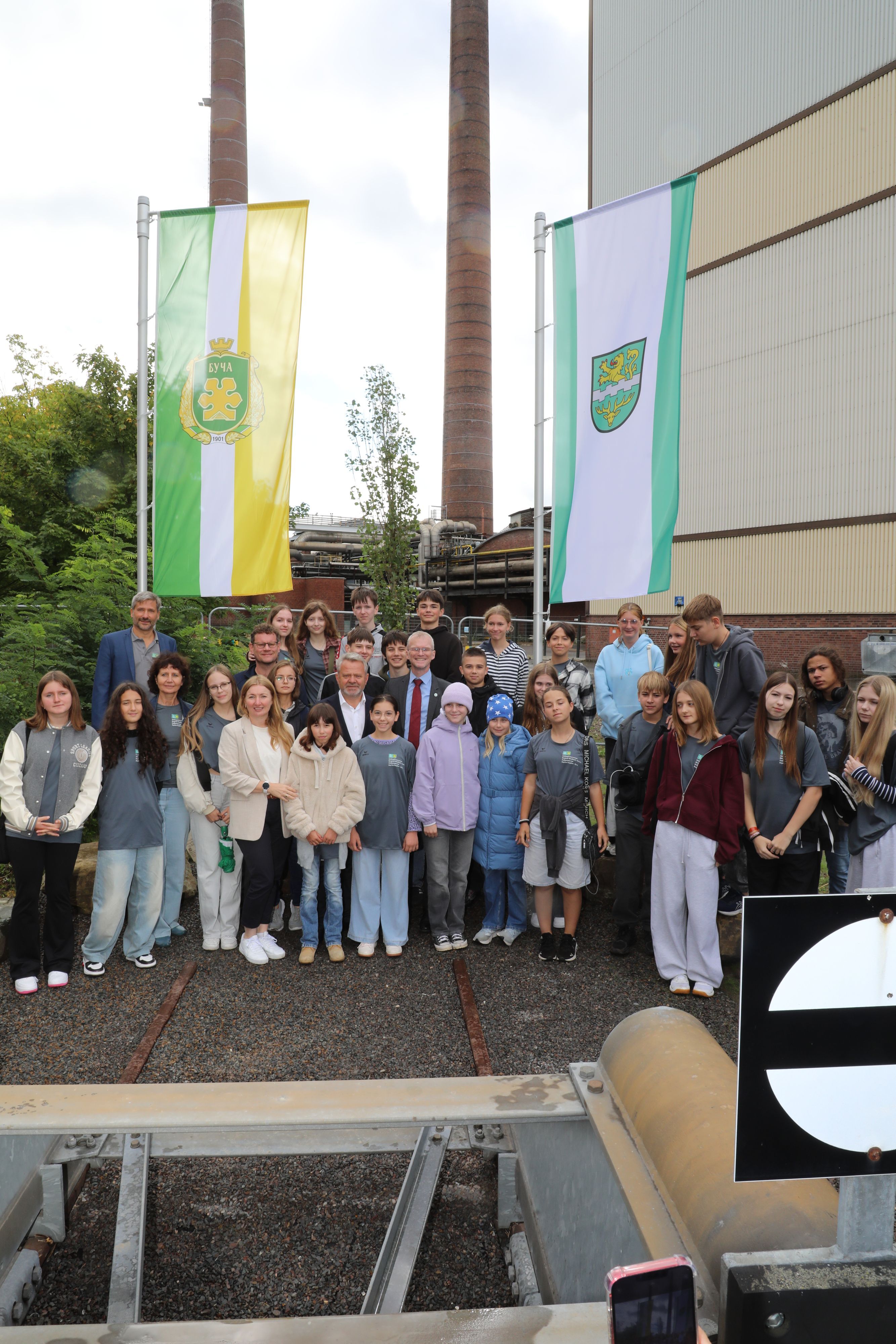 Schüler und Delegationsvertreter aus Butscha stehen am neuen Butscha-Platz in Bergisch Gladbach.